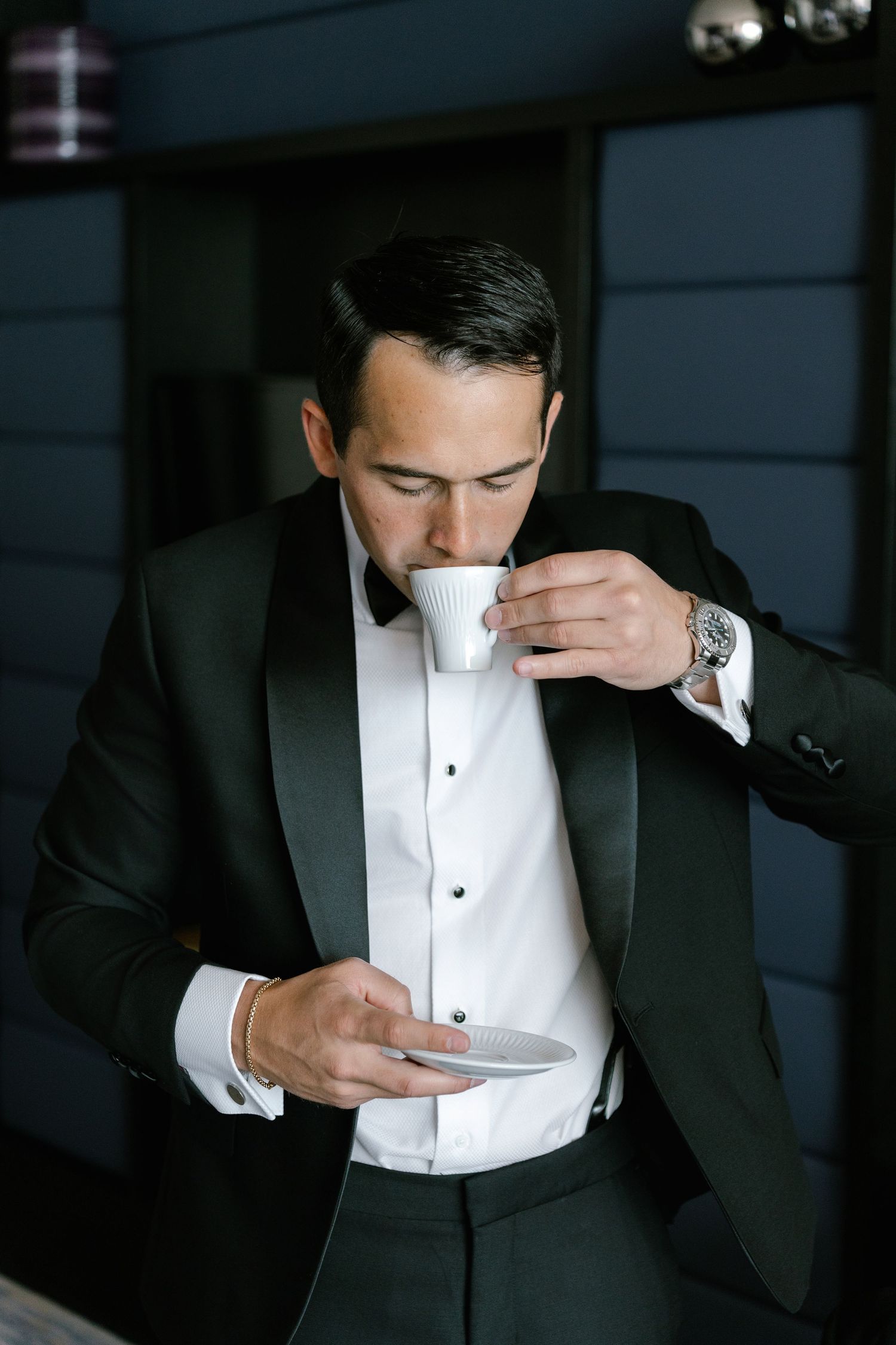 Close-up shots of a groom adjusting his bowtie and white dress shirt before the wedding ceremony.