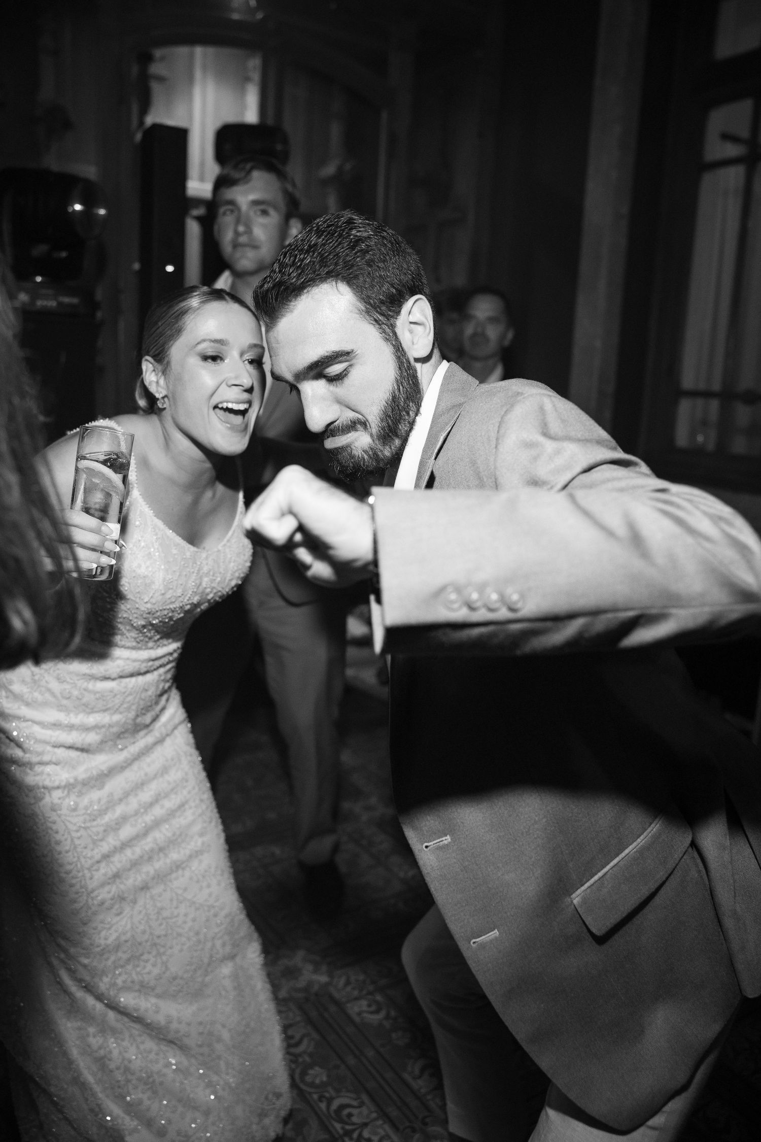 Black and white photo of energetic dancing at a wedding reception.
