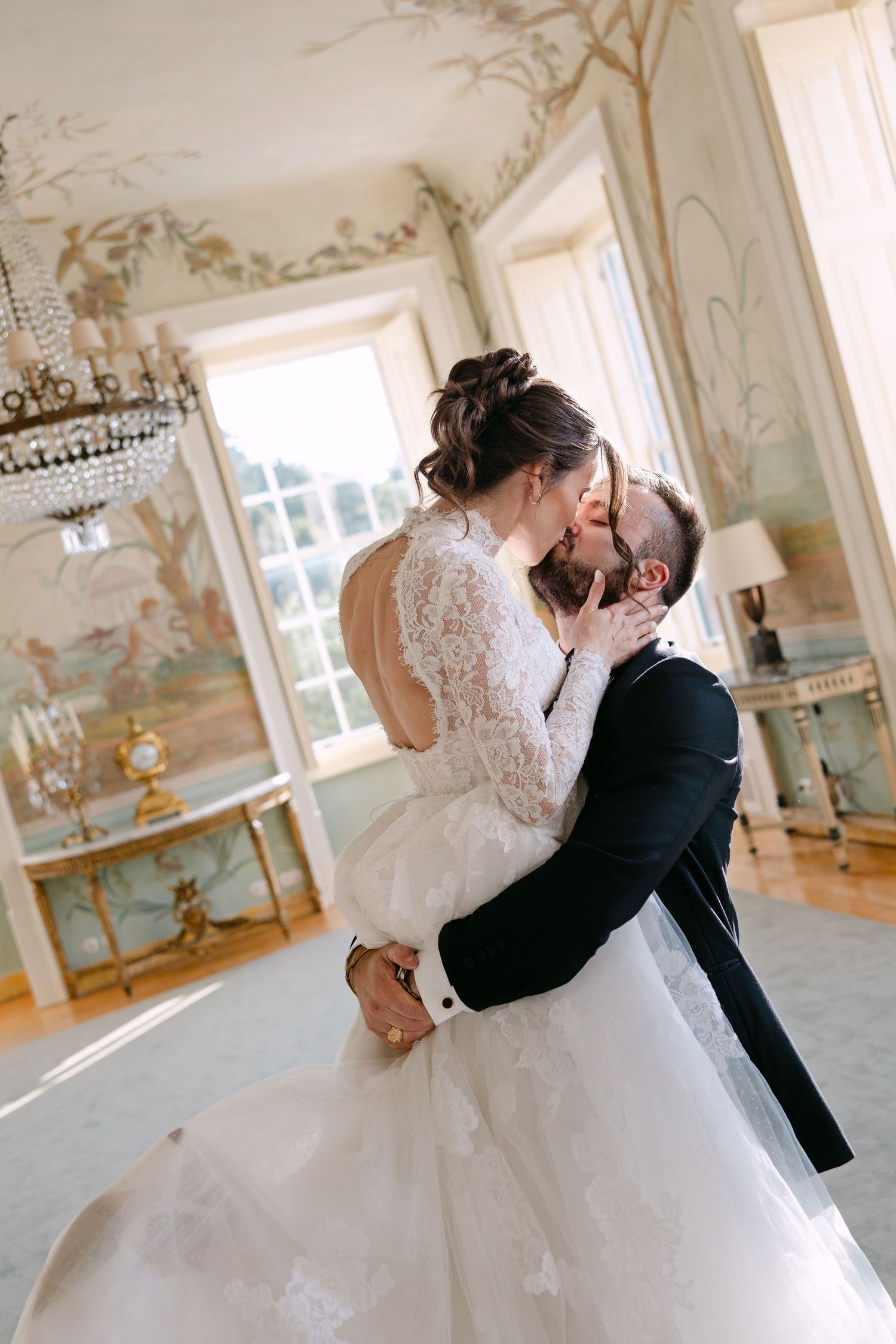 Romantic wedding couple sharing an intimate dance moment in an elegant room with ornate details.