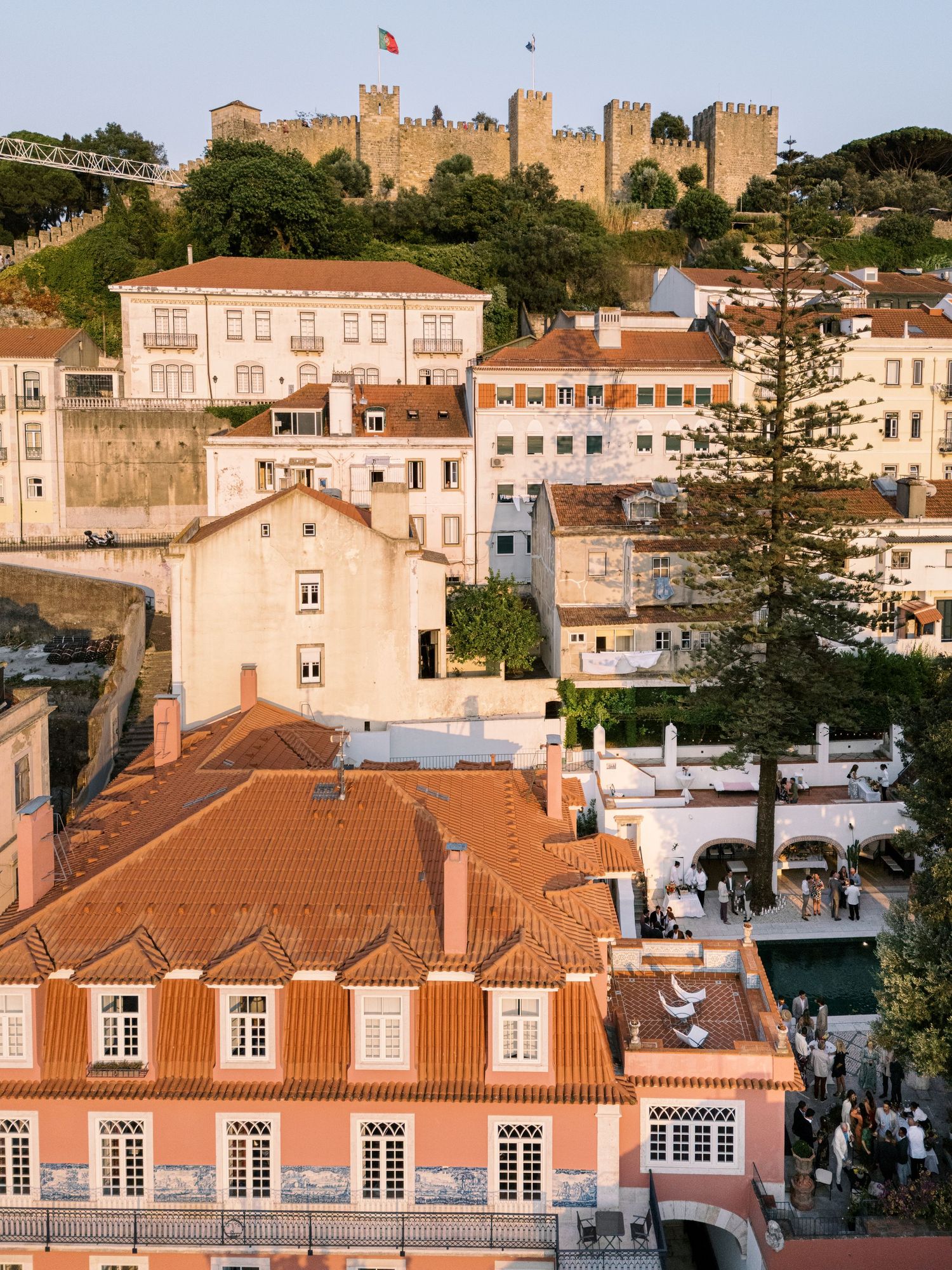 Aerial view of Lisbon's historic district with terracotta rooftops and São Jorge Castle on the hill, Portugal.