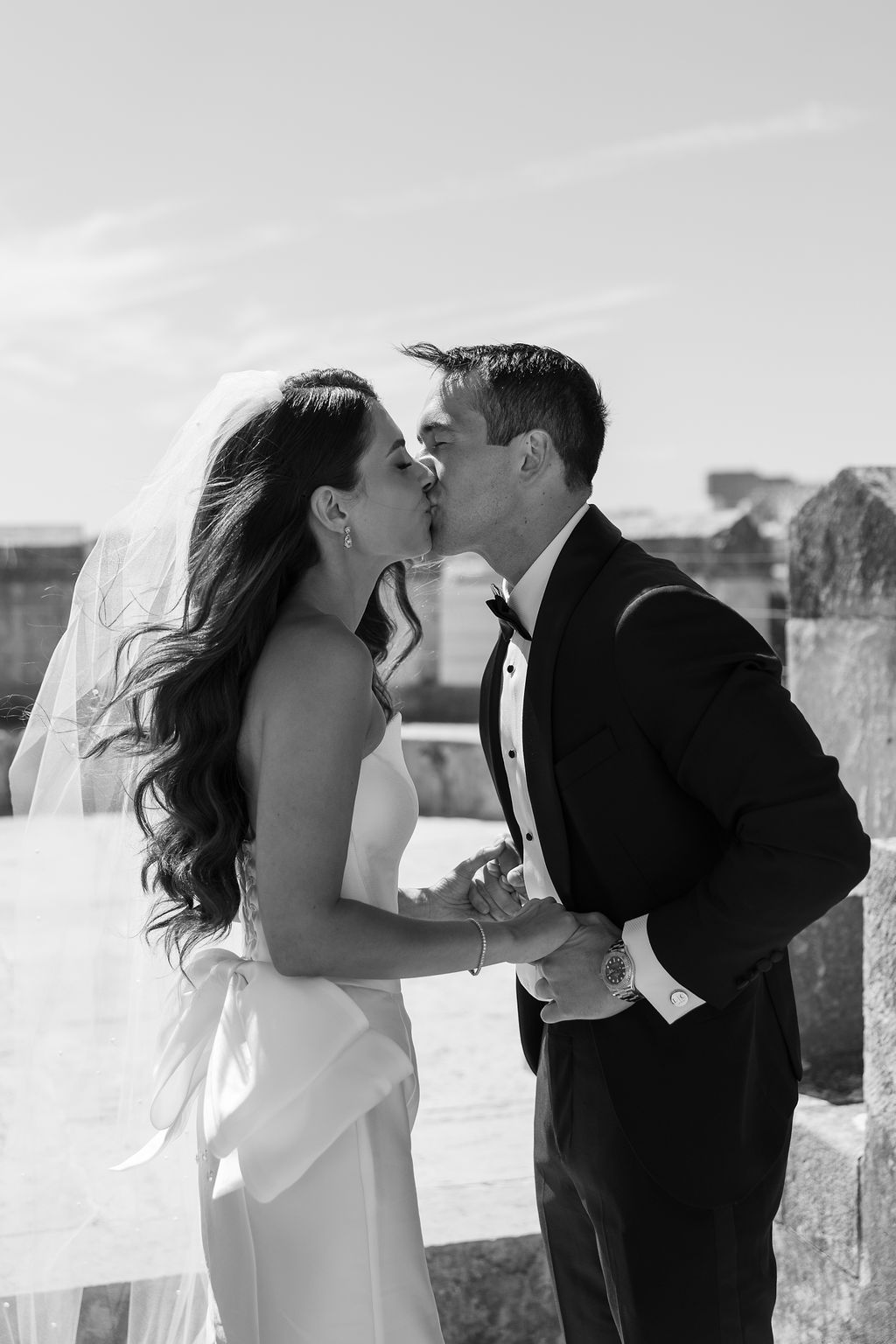 Black and white romantic wedding portraits against stone architecture.