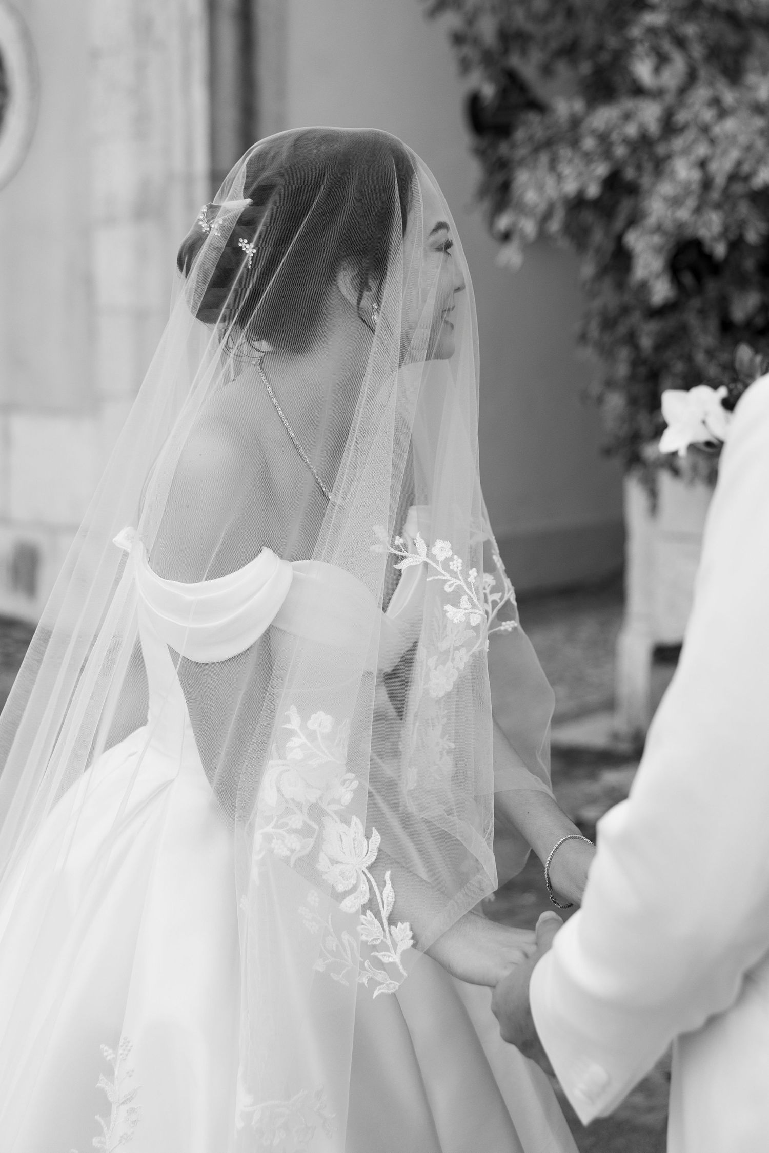 Close-up details of delicate white wedding veil with floral embroidery.