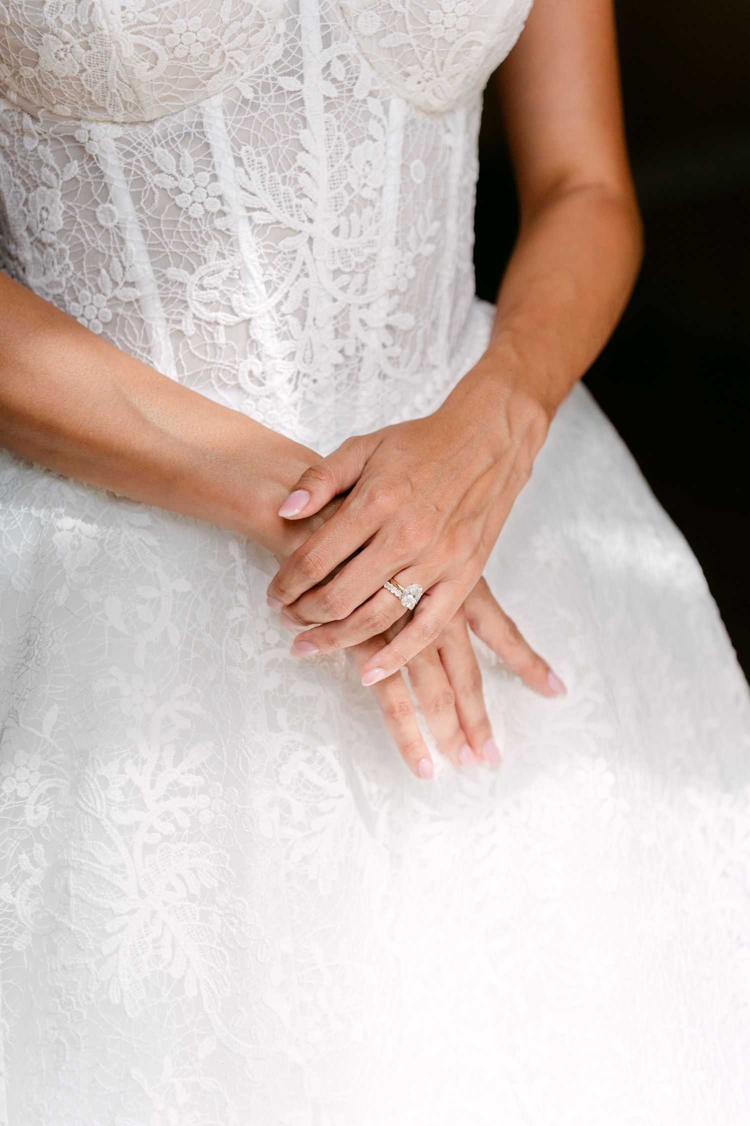 Close-up details of intricate lace and beading on a white wedding dress.