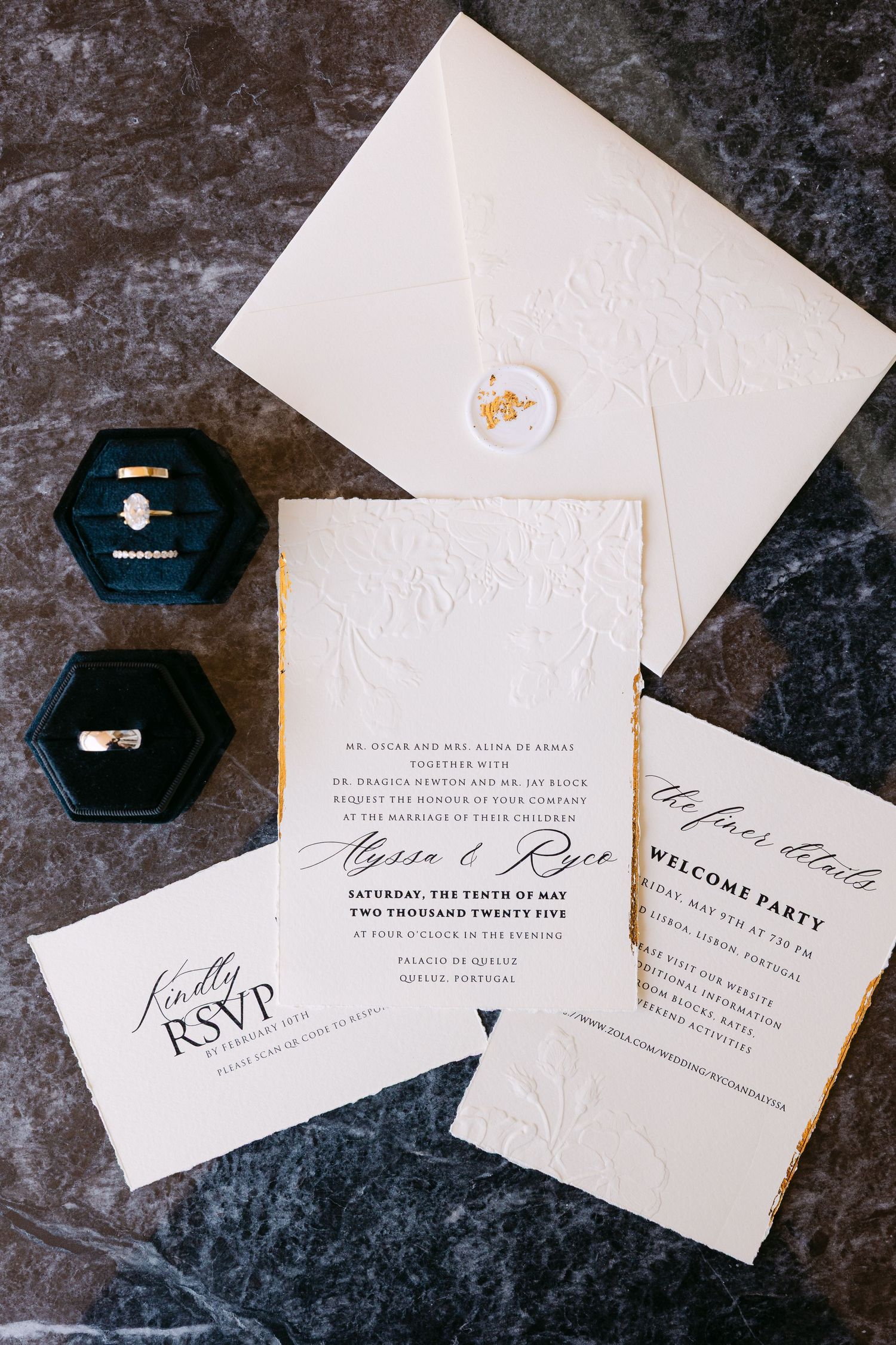 Classic white wedding invitation suite with embossed details and hexagonal ring boxes on dark background.