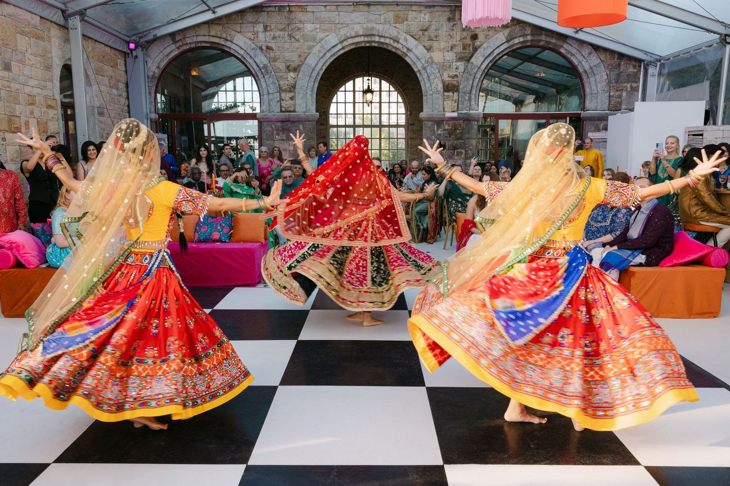Colorful traditional Indian lehengas and wedding dresses displayed in a row at a boutique.
