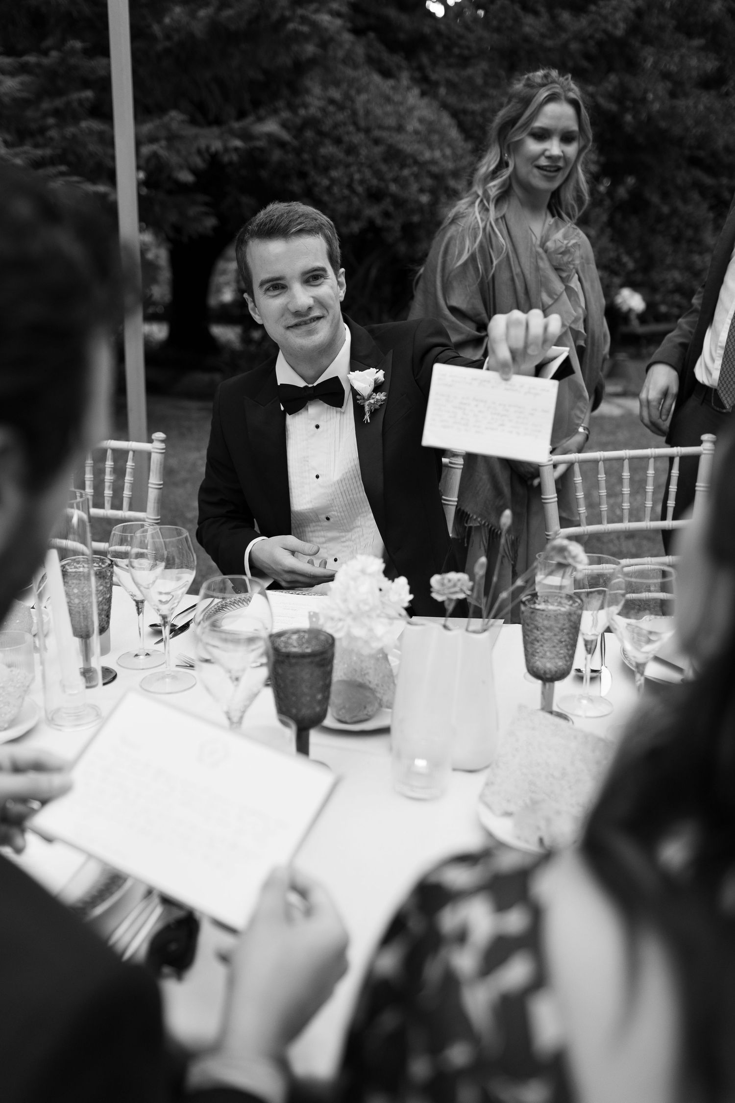 Black and white candid shots of wedding reception table settings and guests.