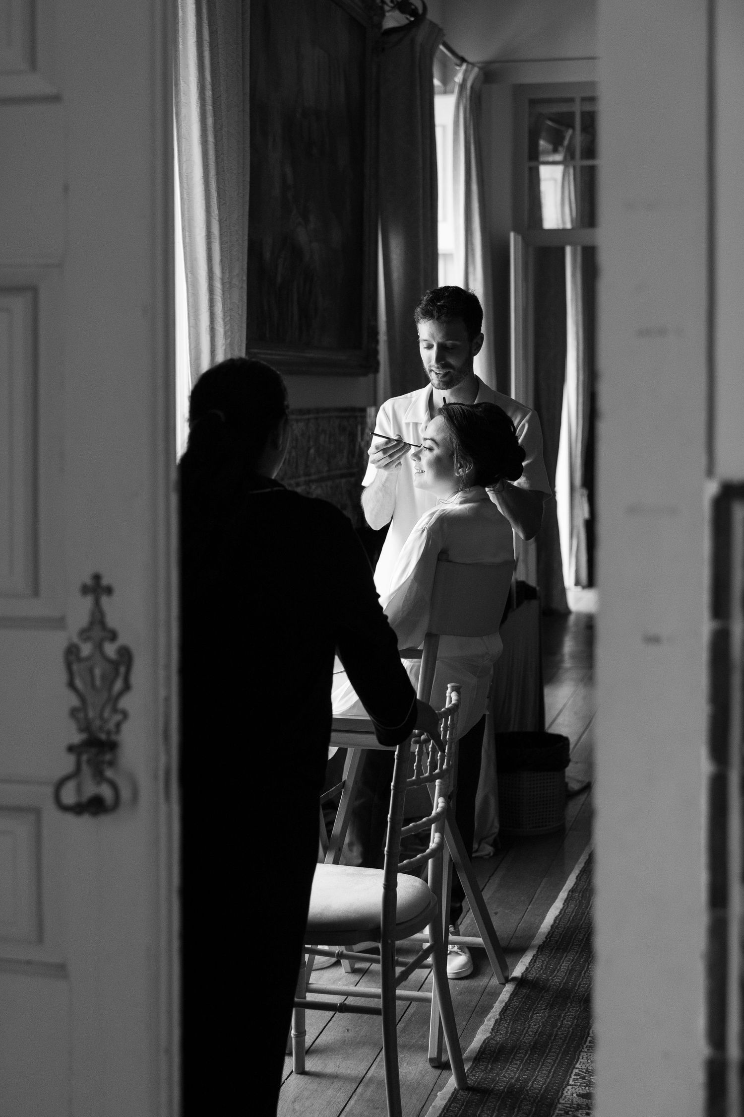 Black and white photo of silhouettes in a bright corridor with dramatic lighting.