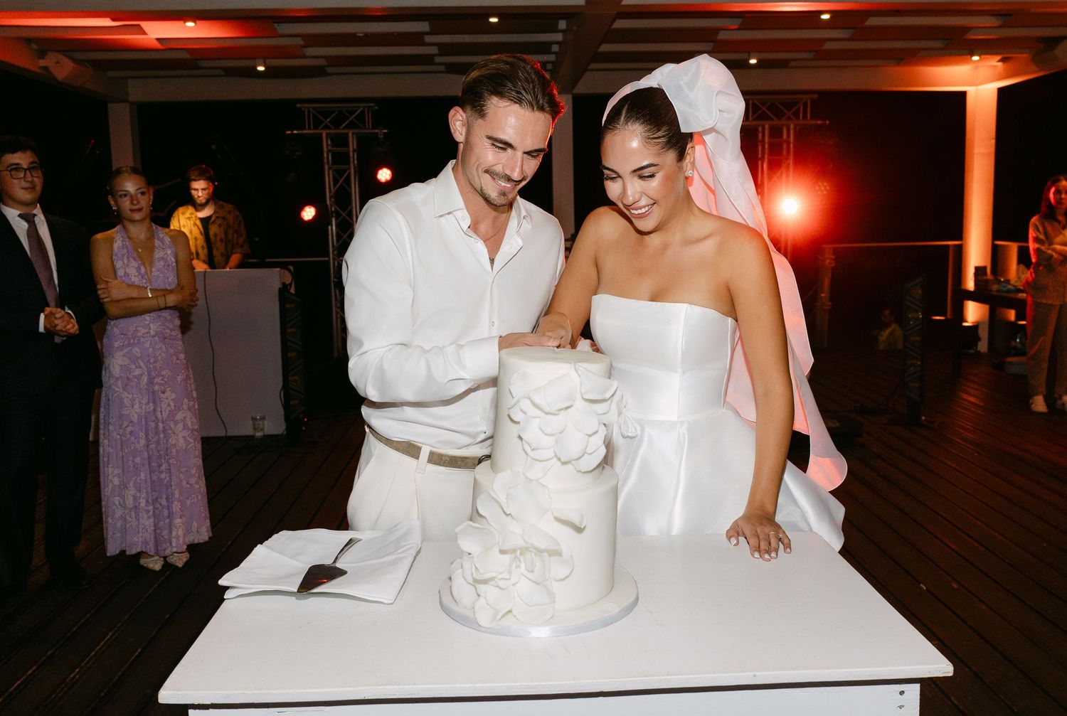 Wedding reception celebration with elegant white decor and lighting.
