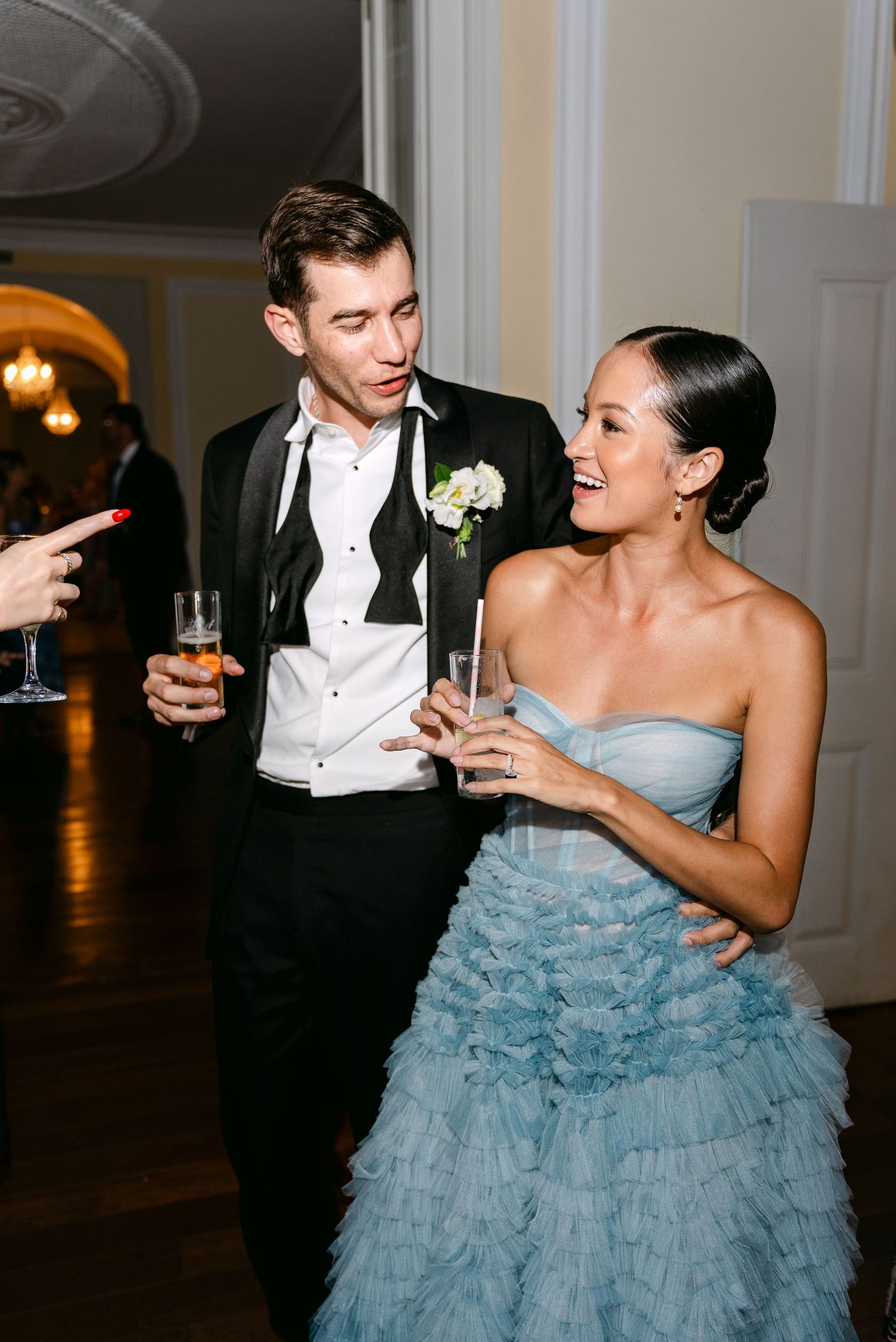 Couple sharing playful moments during their first dance in formal wedding attire.
