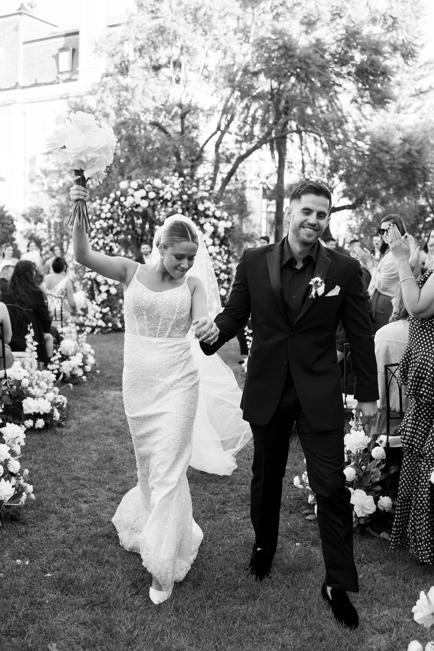 Wedding celebration candid moments captured on grassy lawn with floral decor.