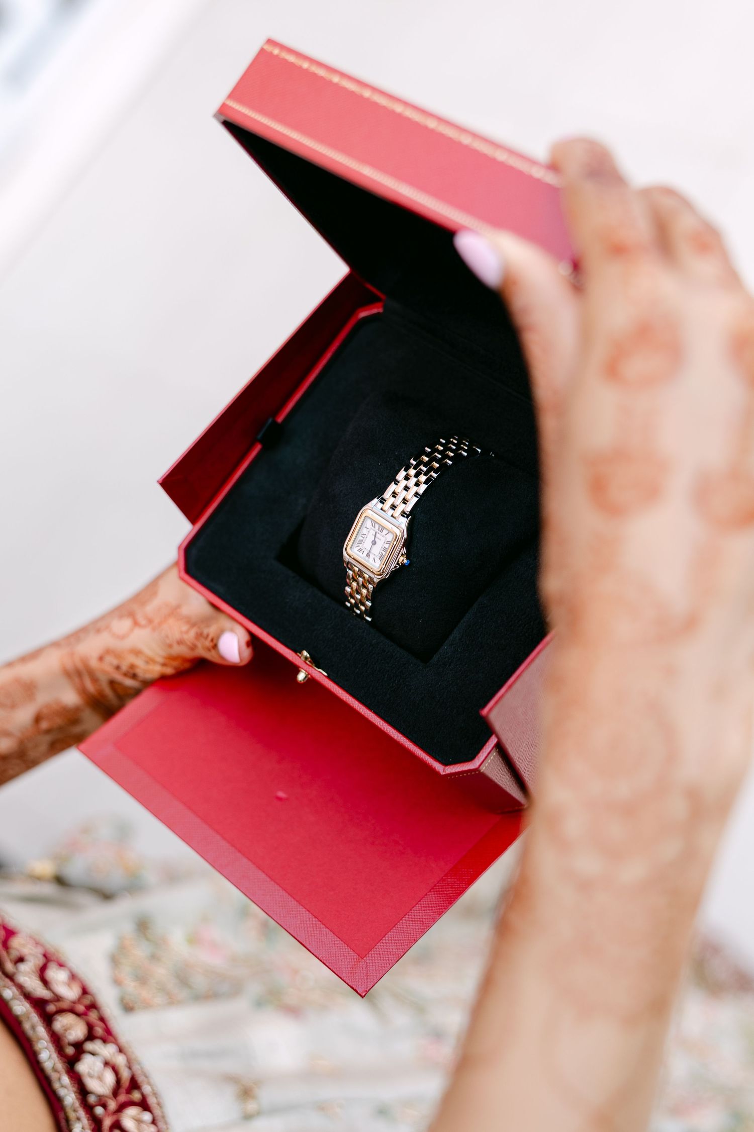 Close-up sequence of hands opening a red jewelry box containing an engagement ring.