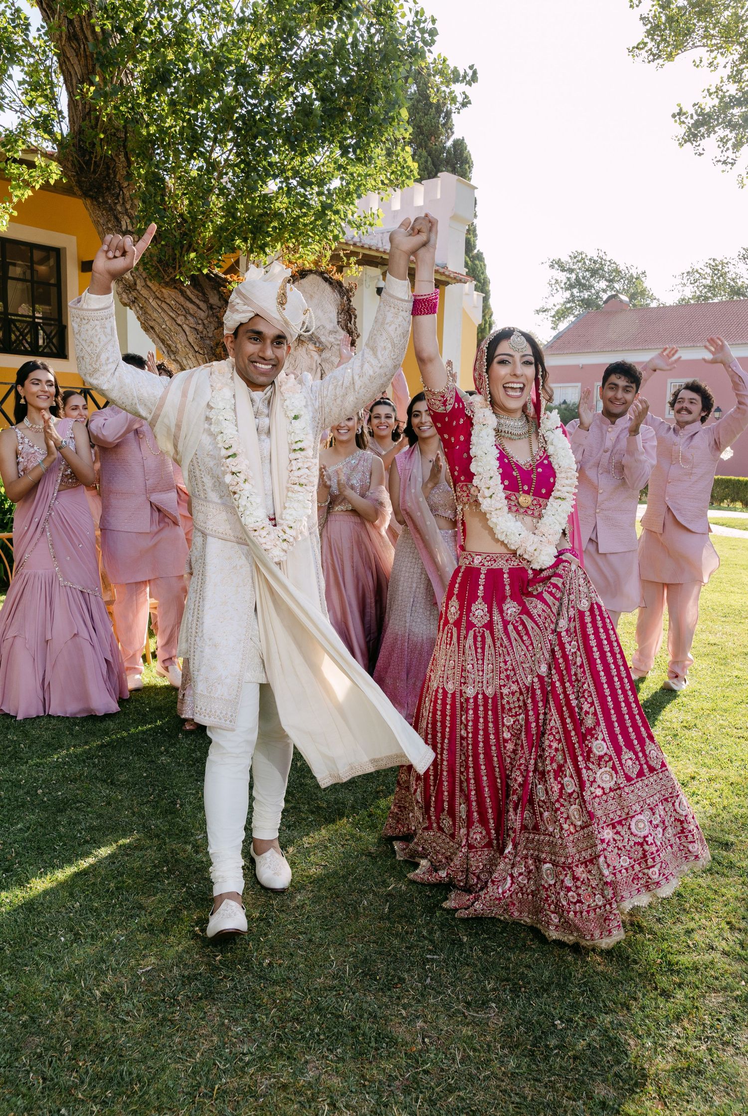 Wedding celebration with traditional Indian attire in pink and white colors outdoors.