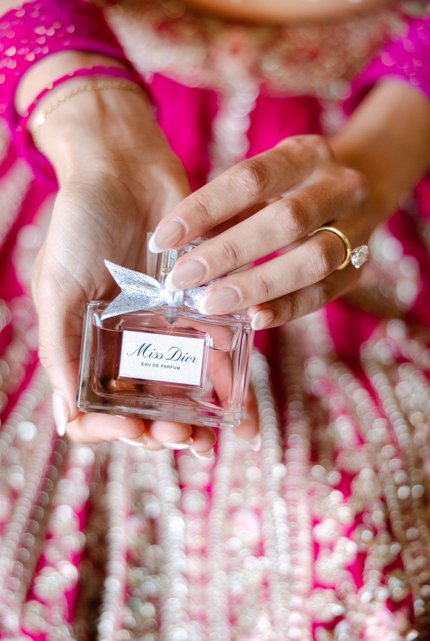 Delicate perfume bottle detail shots with pink fabric and sparkly elements in the background.