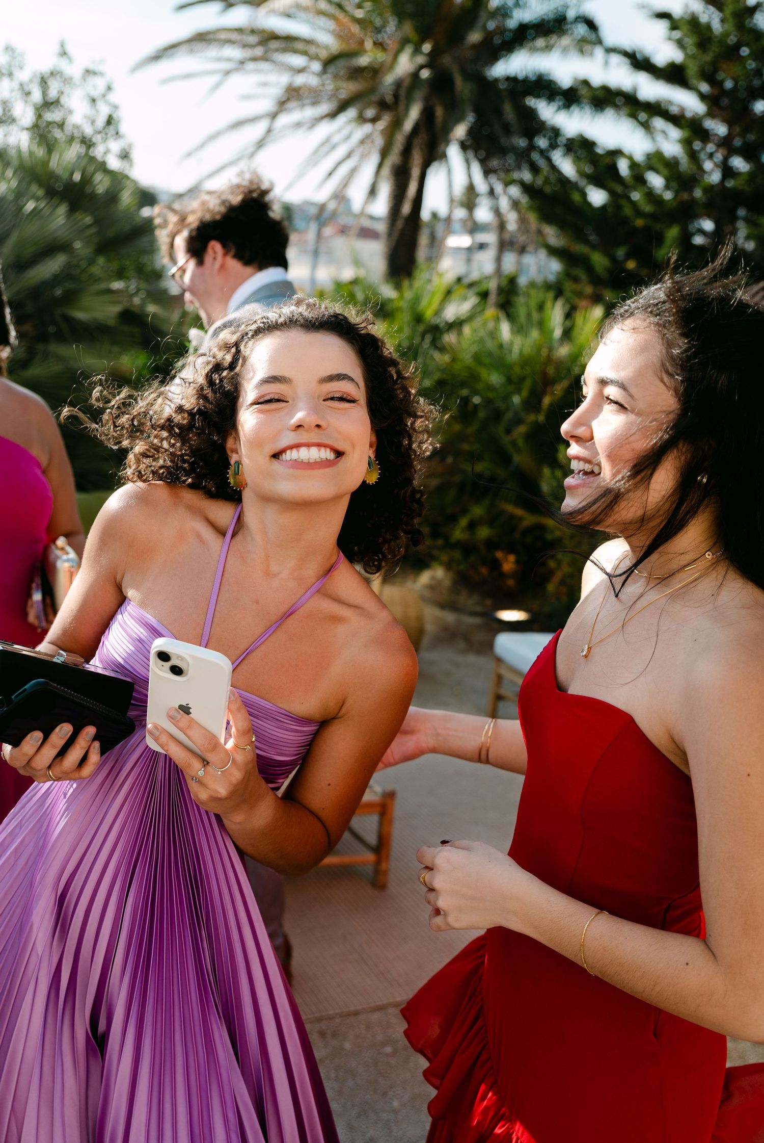 Candid moments of bridesmaids laughing and celebrating in purple and red dresses.