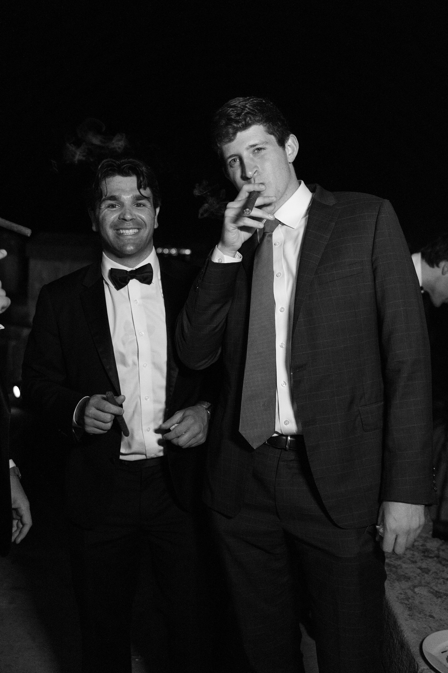 Two men in formal attire enjoying a nighttime celebration.