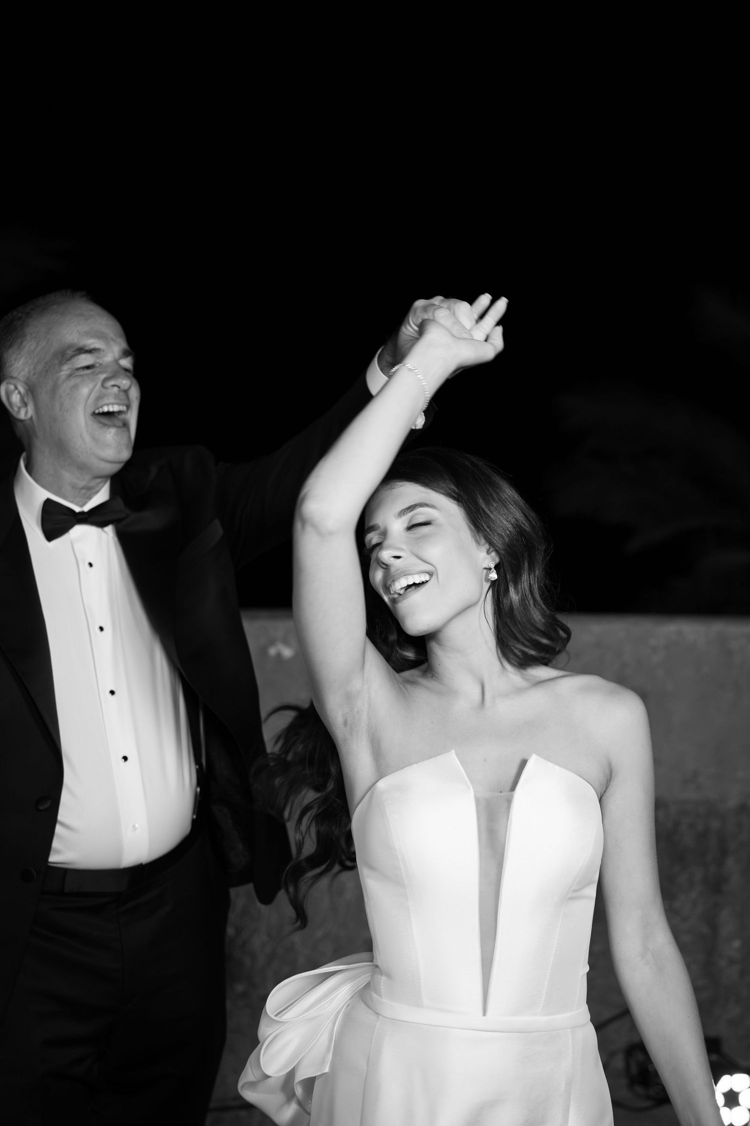 Black and white photo of joyful dancing at an elegant formal event.