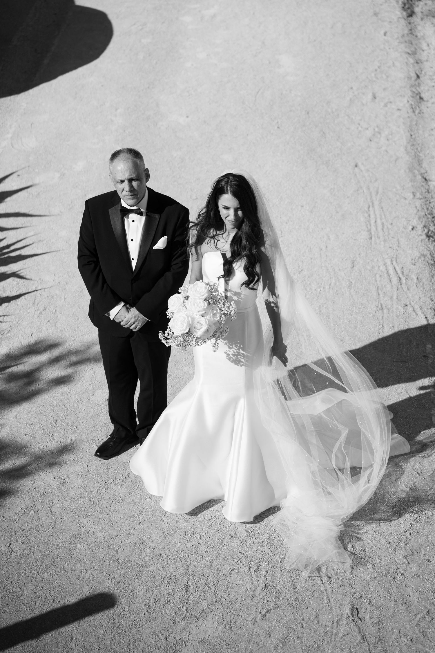Black and white wedding portraits captured from above showing elegant bridal gown details.