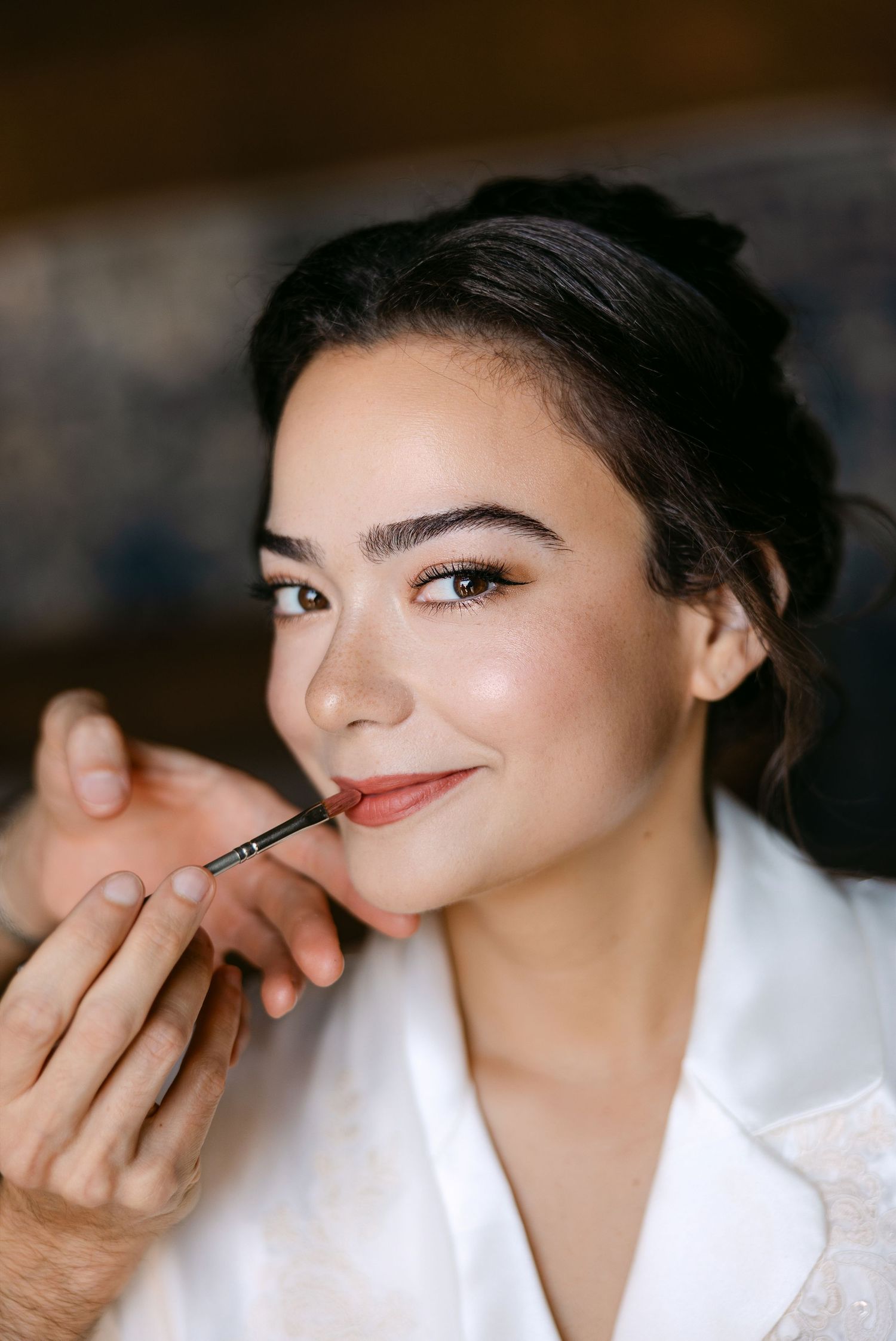 Close-up beauty shots showing makeup application in soft lighting.