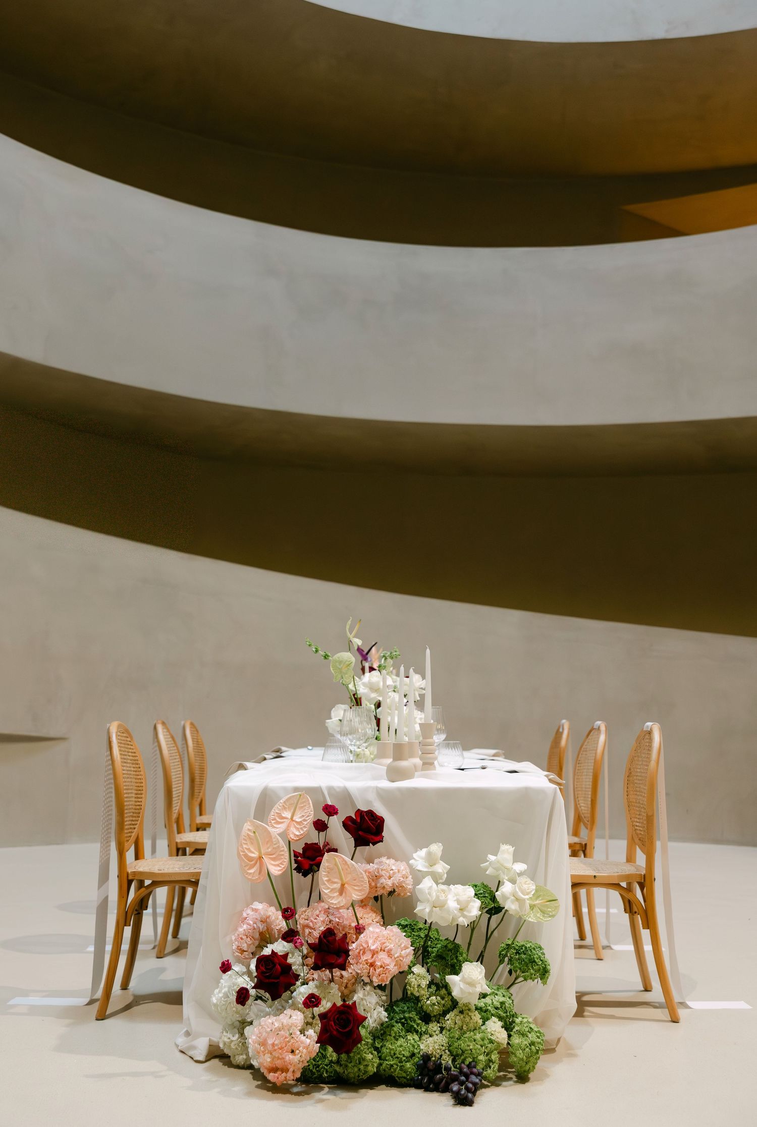 Elegant sweetheart table with lush floral arrangements at the Guggenheim Museum wedding reception.