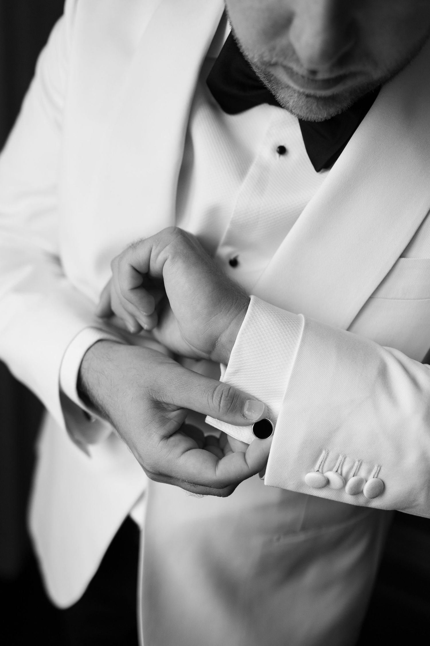 Close-up shots of hands adjusting white formal wear cuffs and buttons.