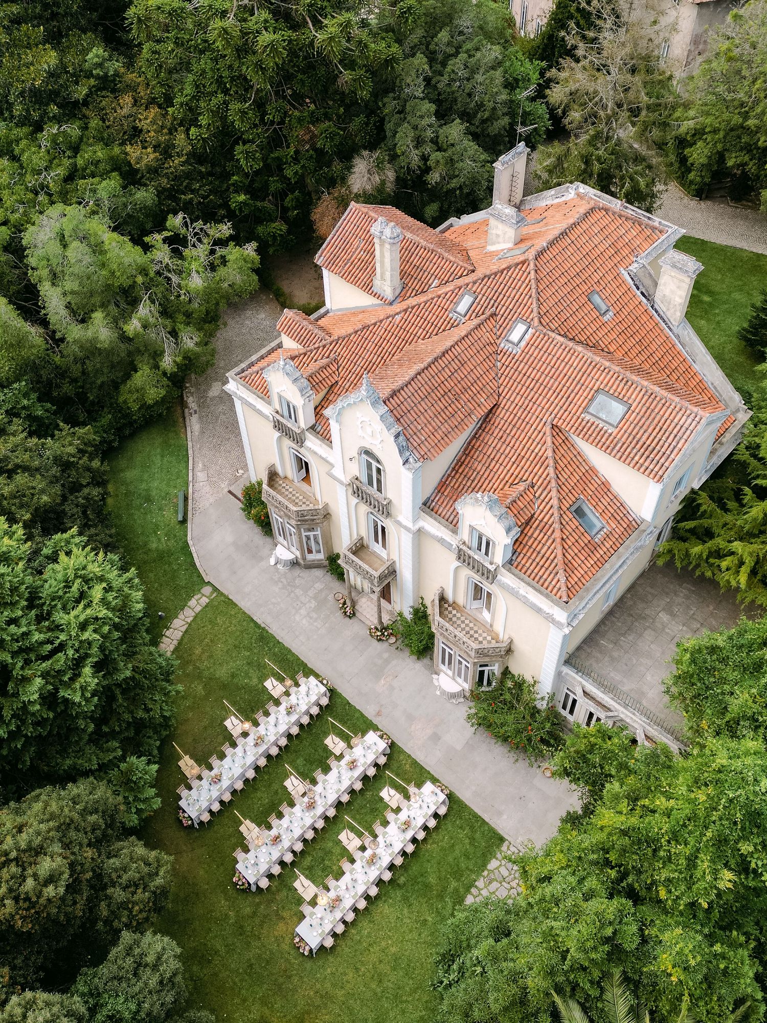 Drone shot of a beautiful villa with outdoor wedding setup in the garden.