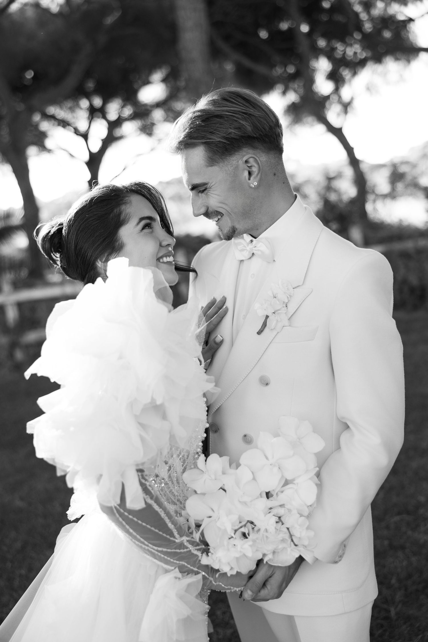 Romantic black and white wedding portraits showing tender moments outdoors.
