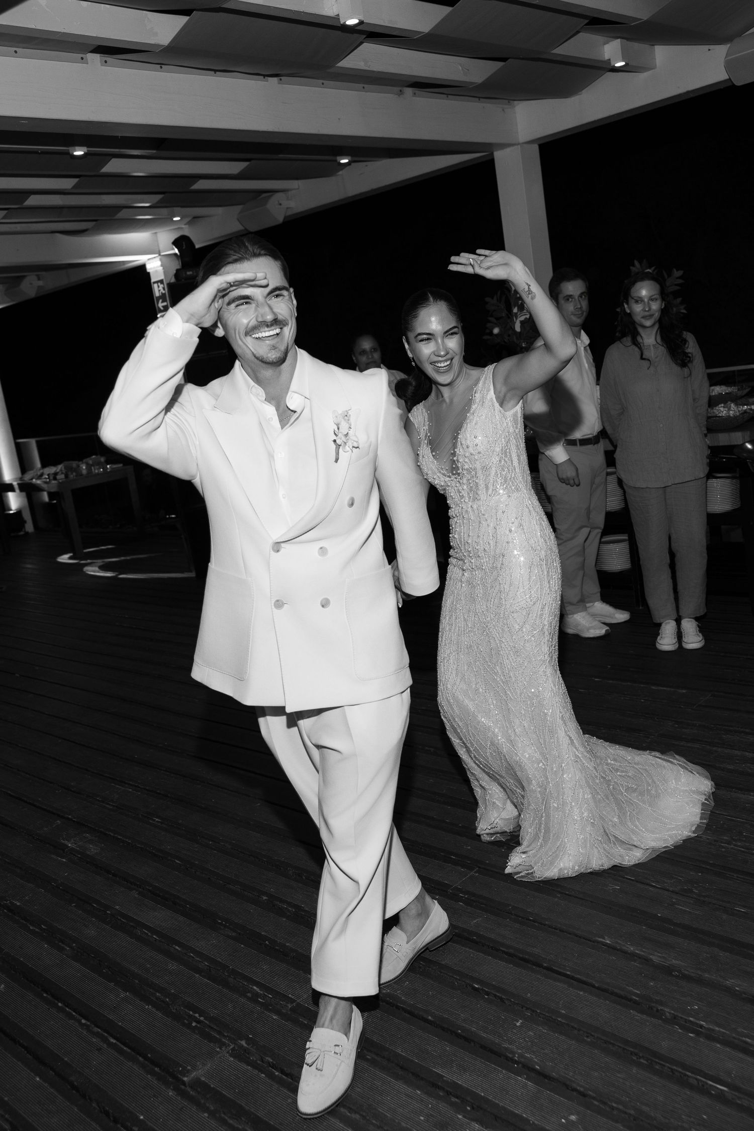 Wedding celebration with dancing and festivities on a wooden dance floor.