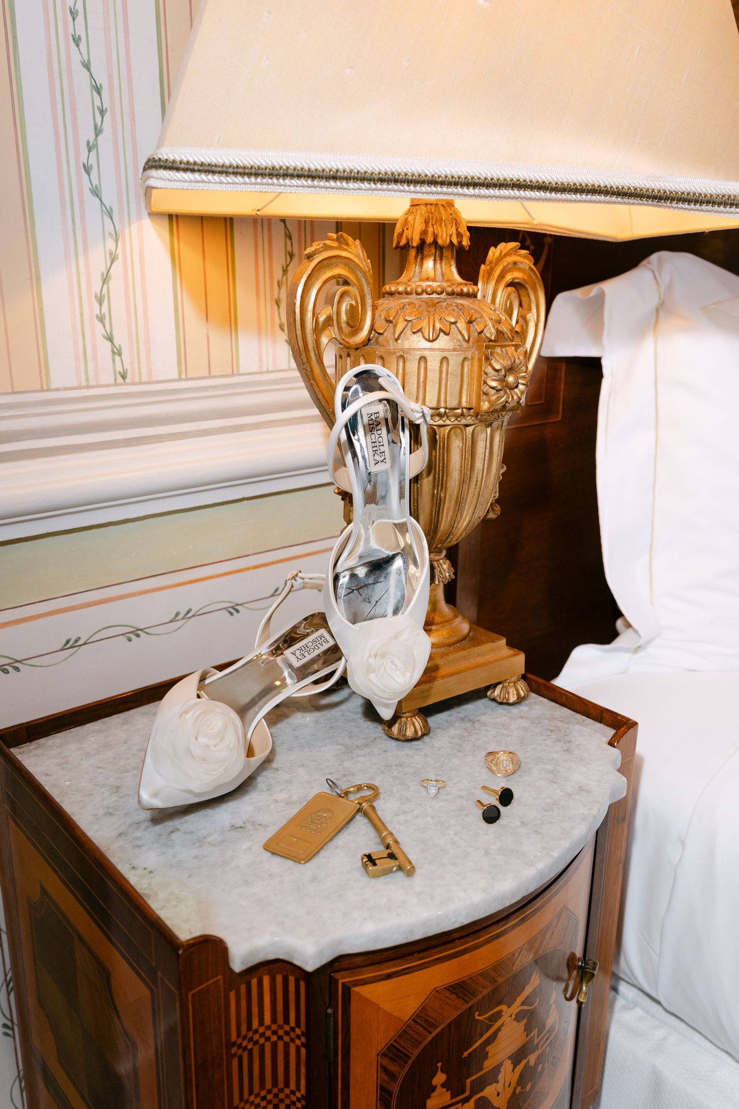Vintage-style marble table displays decorative silver pitcher and antique key.
