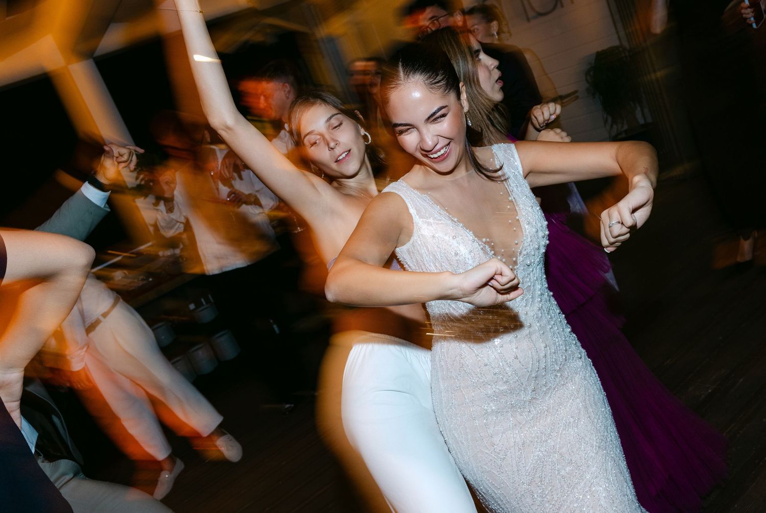 Wedding guests dancing and celebrating at a lively reception party.