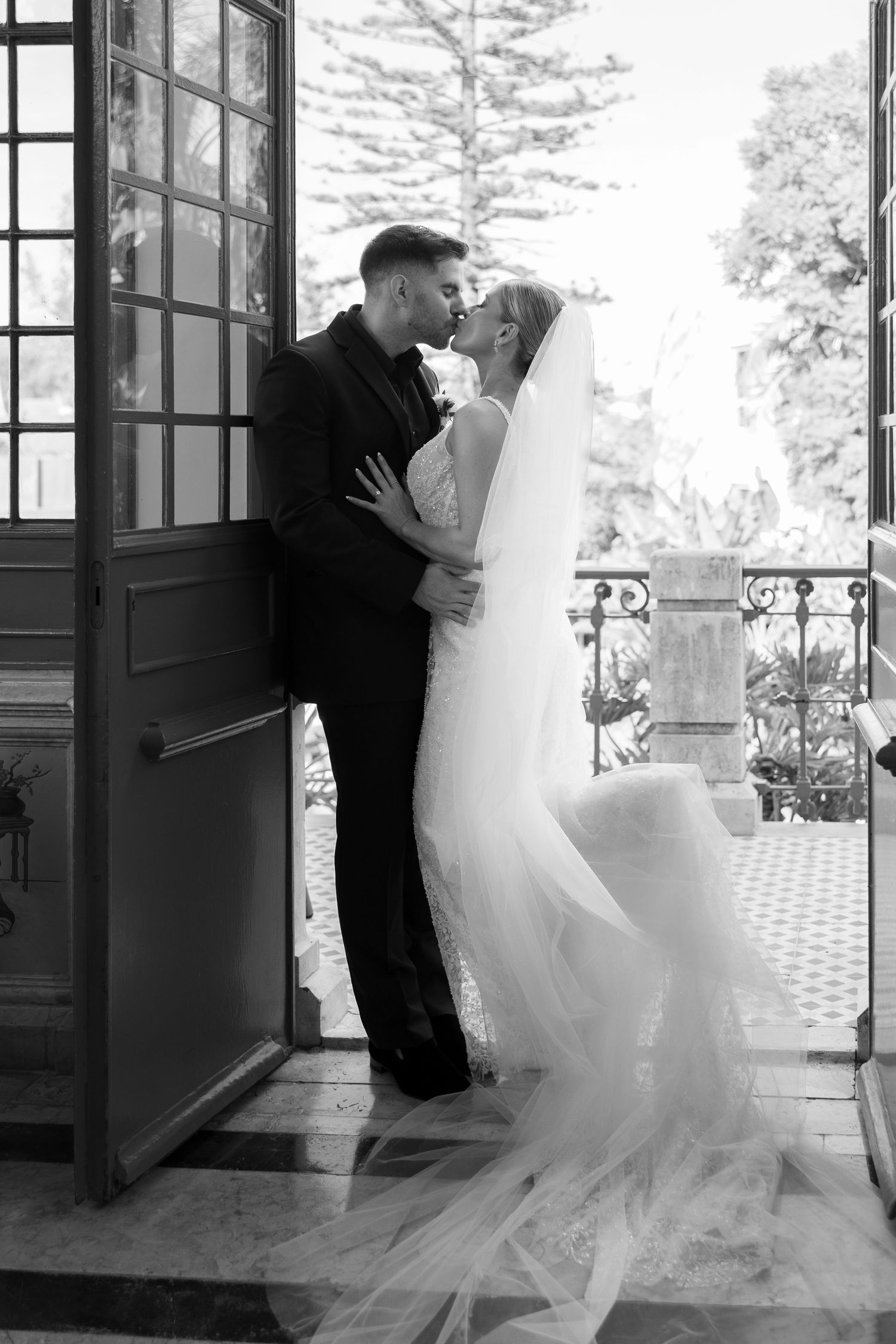 Black and white series of romantic wedding couple portraits in a doorway.