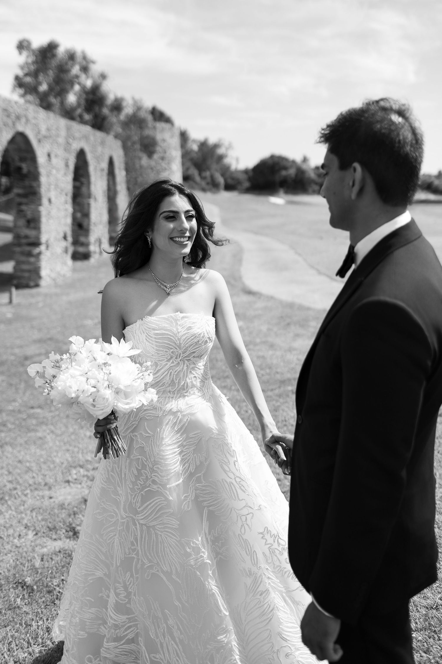 Black and white wedding portraits showing tender moments between a couple against a scenic outdoor backdrop.