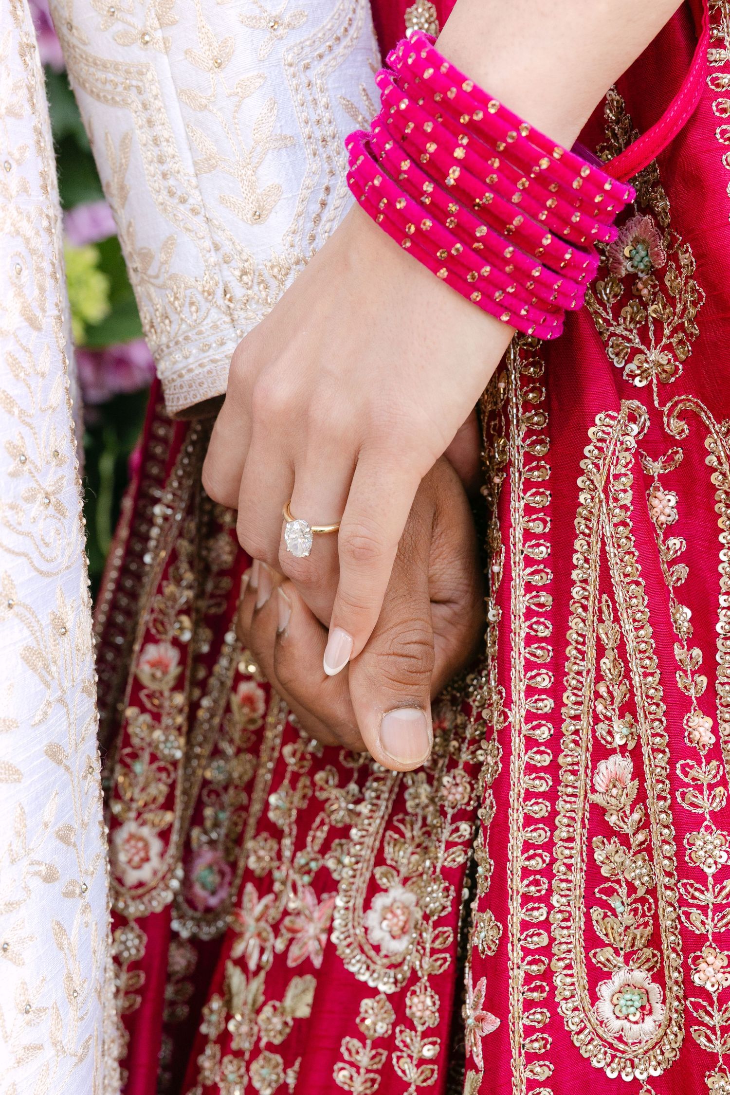 Detail shots of hands showing wedding rings and intricate embroidery on traditional Indian wedding attire.