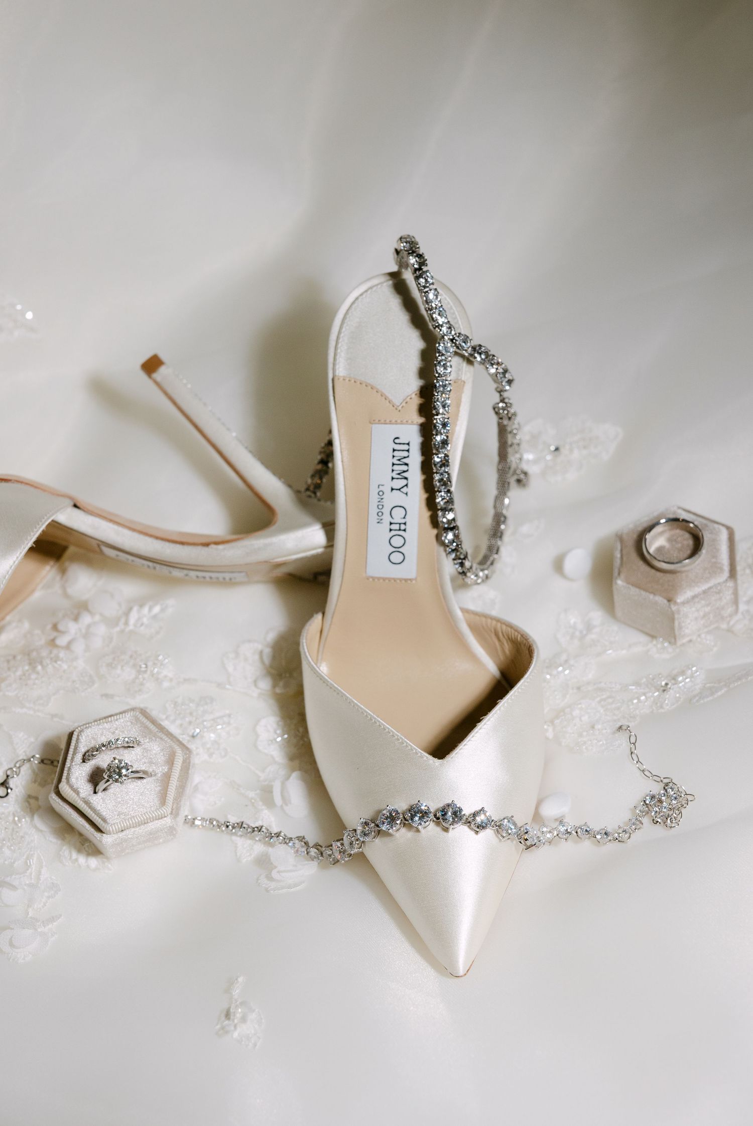 White slingback wedding shoe with crystal details and hexagonal ring boxes on lace.