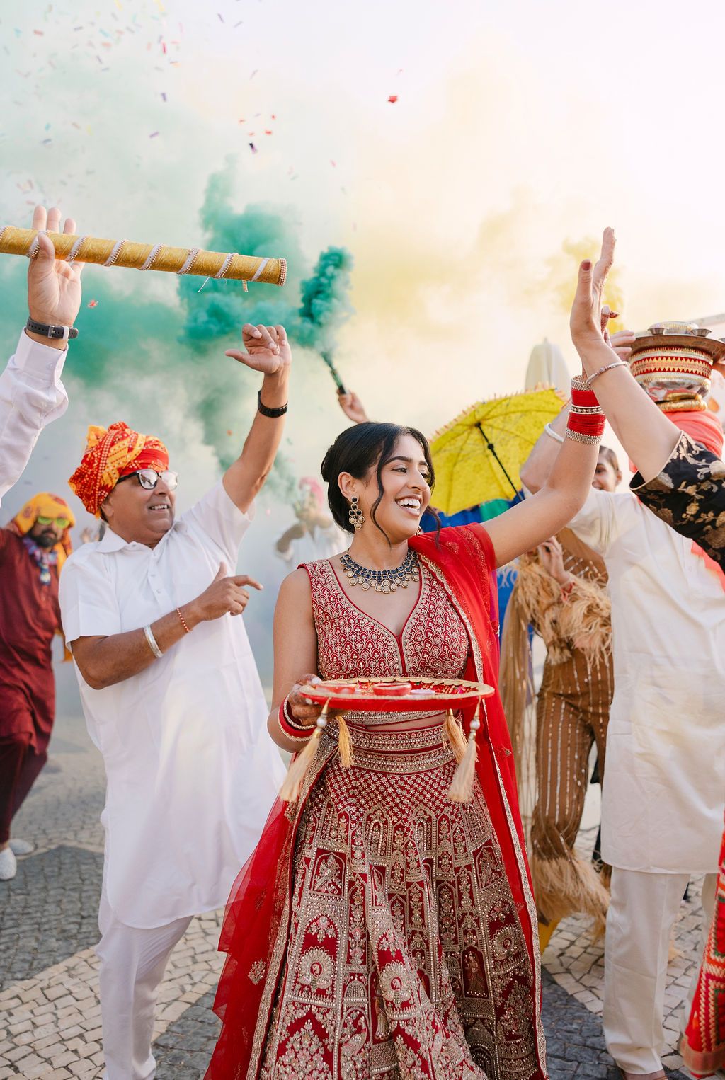Joyful wedding celebration with guests dancing in traditional Indian and western attire at outdoor venue.