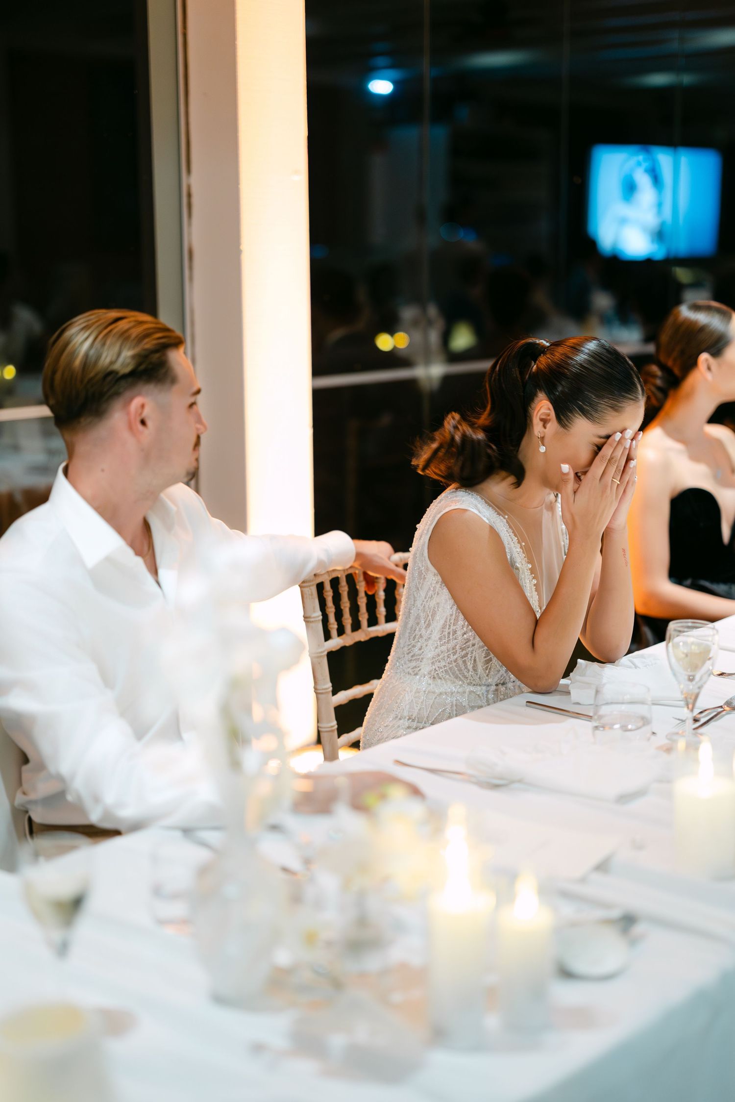 Emotional wedding reception moment captured at an elegant dinner table.