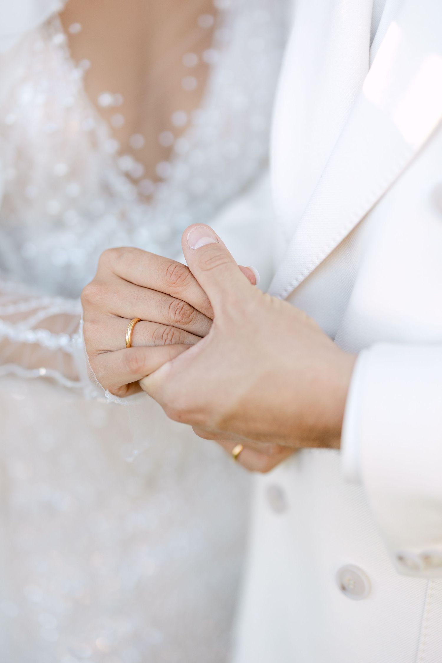 Close-up shots of hands with wedding rings in delicate white lace.