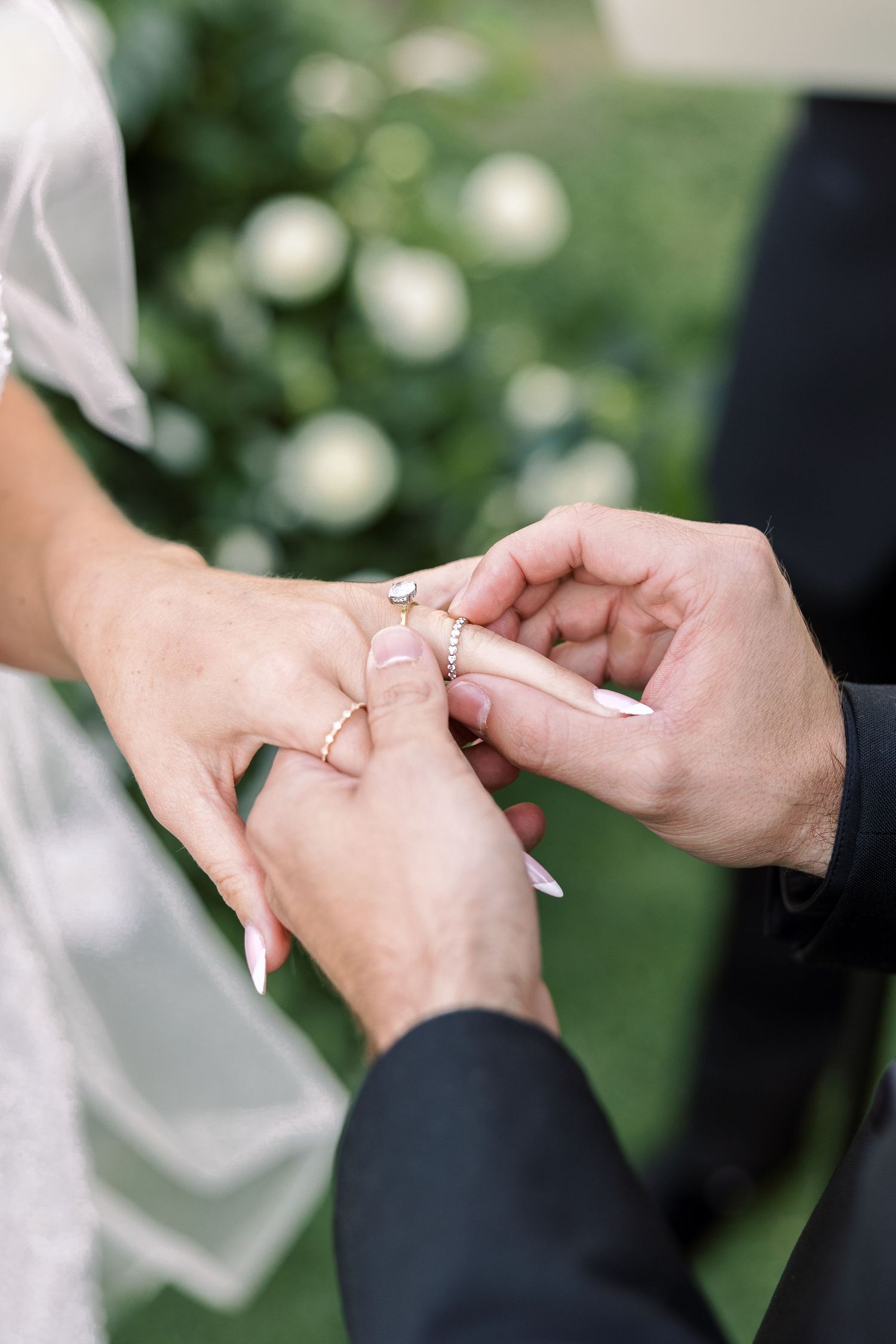 Close-up photos of hands exchanging wedding rings during a ceremony.