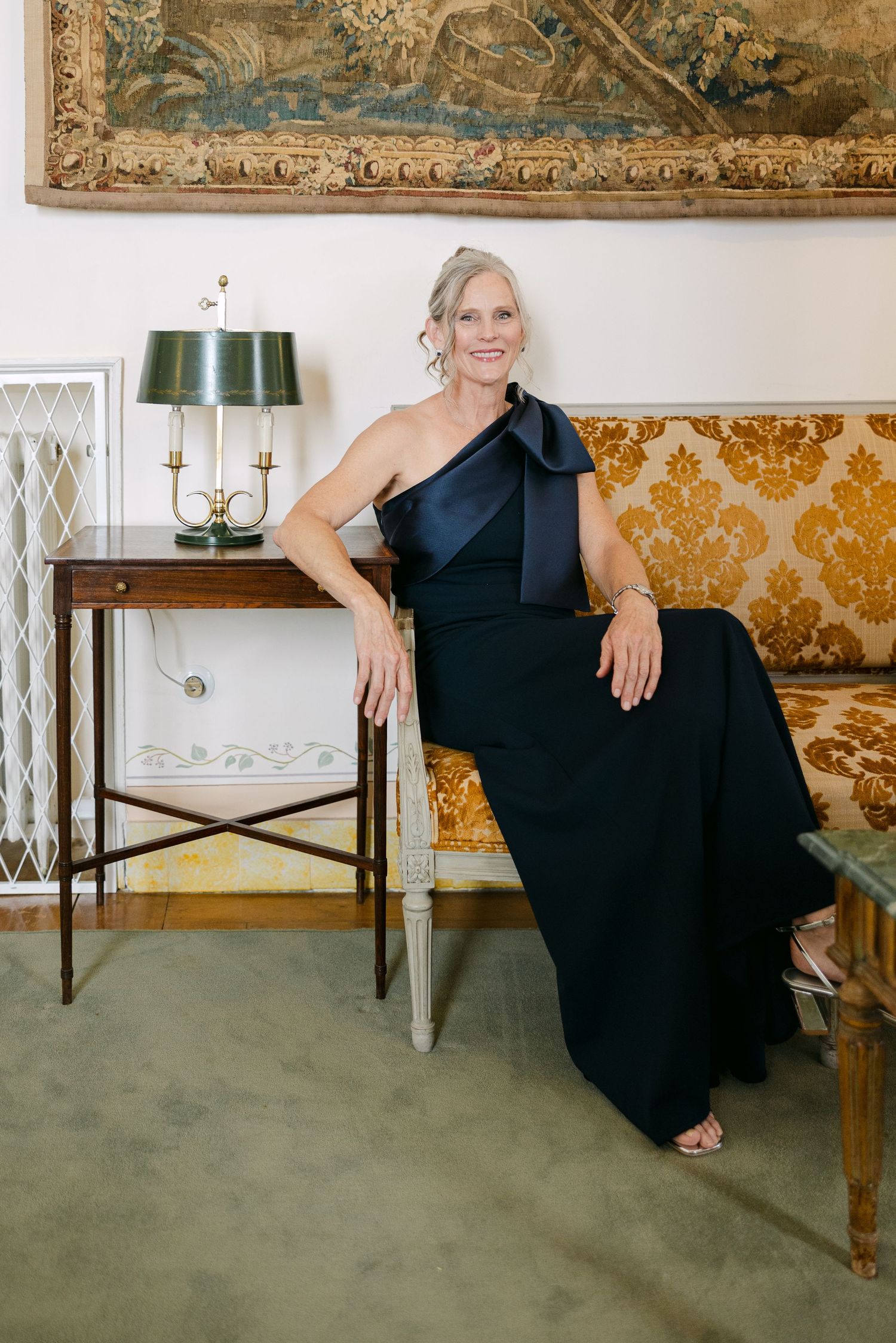 Elegant formal portraits in vintage room with ornate wallpaper and artwork.