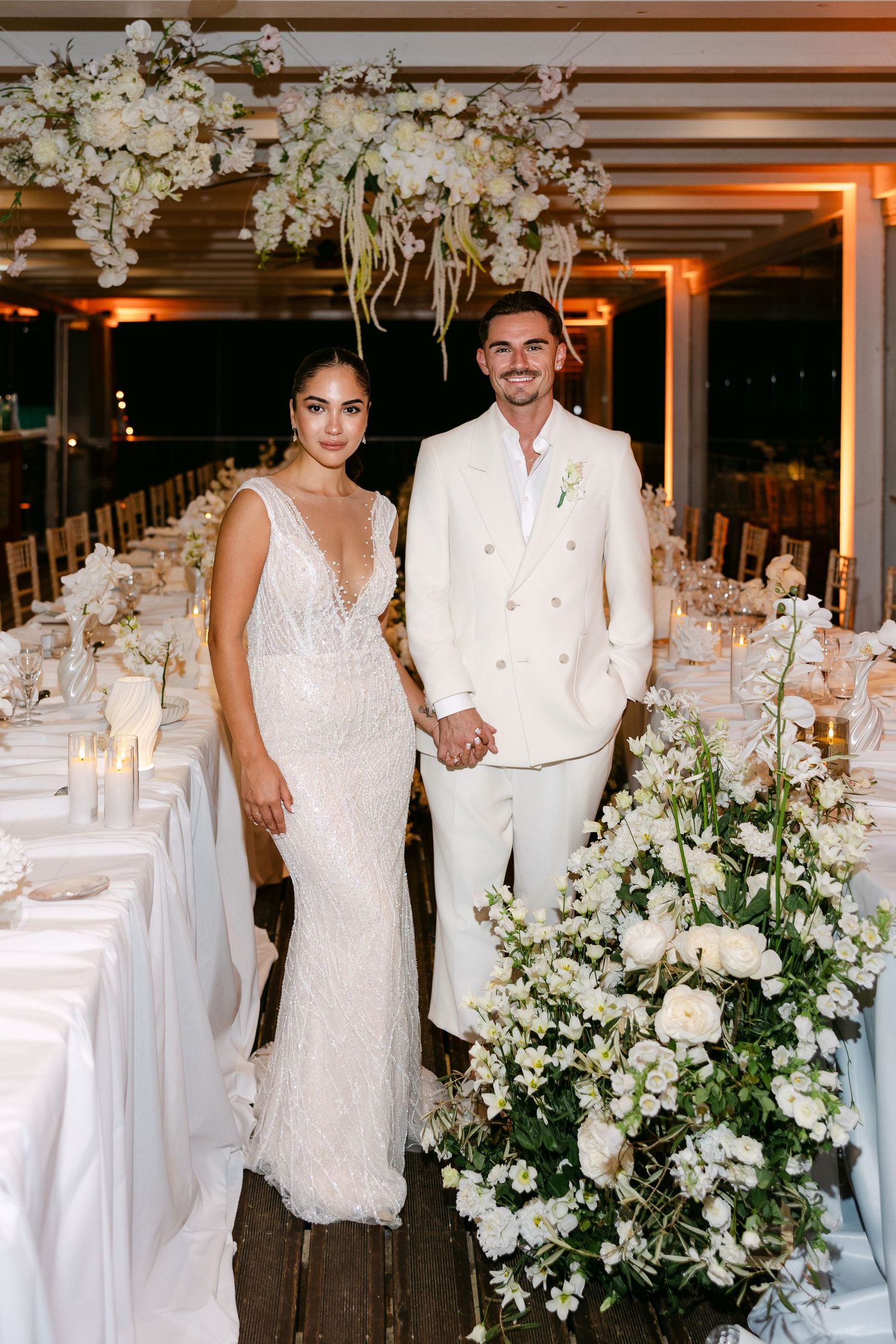 Wedding reception venue decorated with white flowers and elegant table settings.