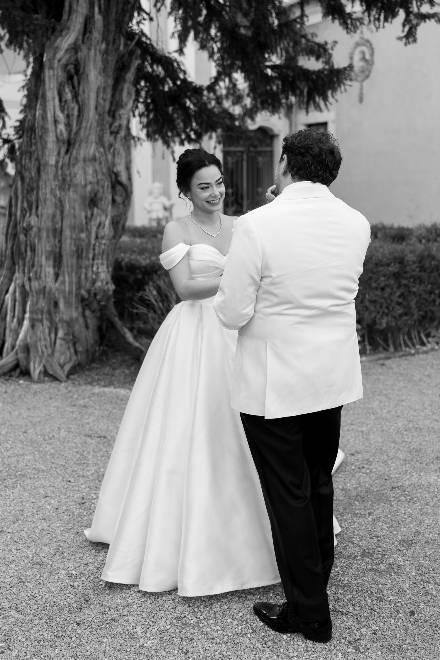 Black and white photos of a couple in formal wedding attire dancing outdoors.