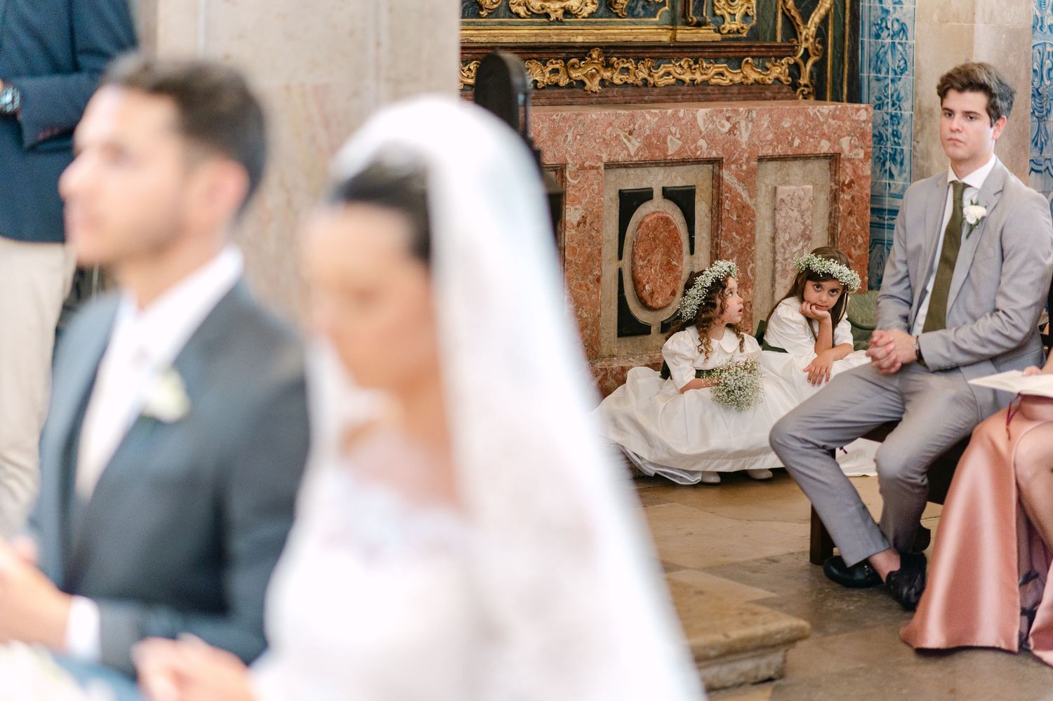 Wedding guests seated in church pews during the ceremony.