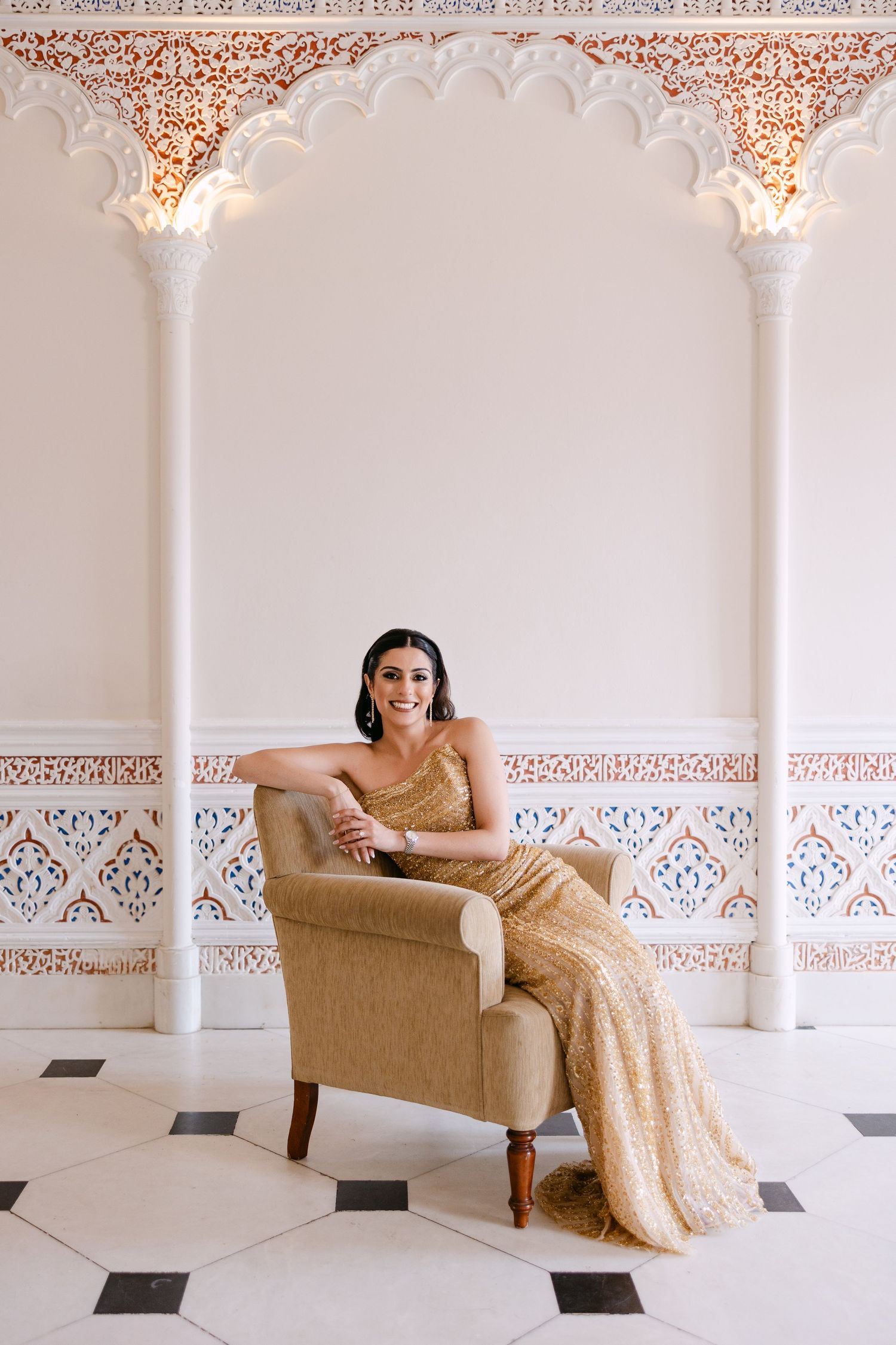 Elegant room with ornate white archways and intricate ceiling details featuring gold accents.