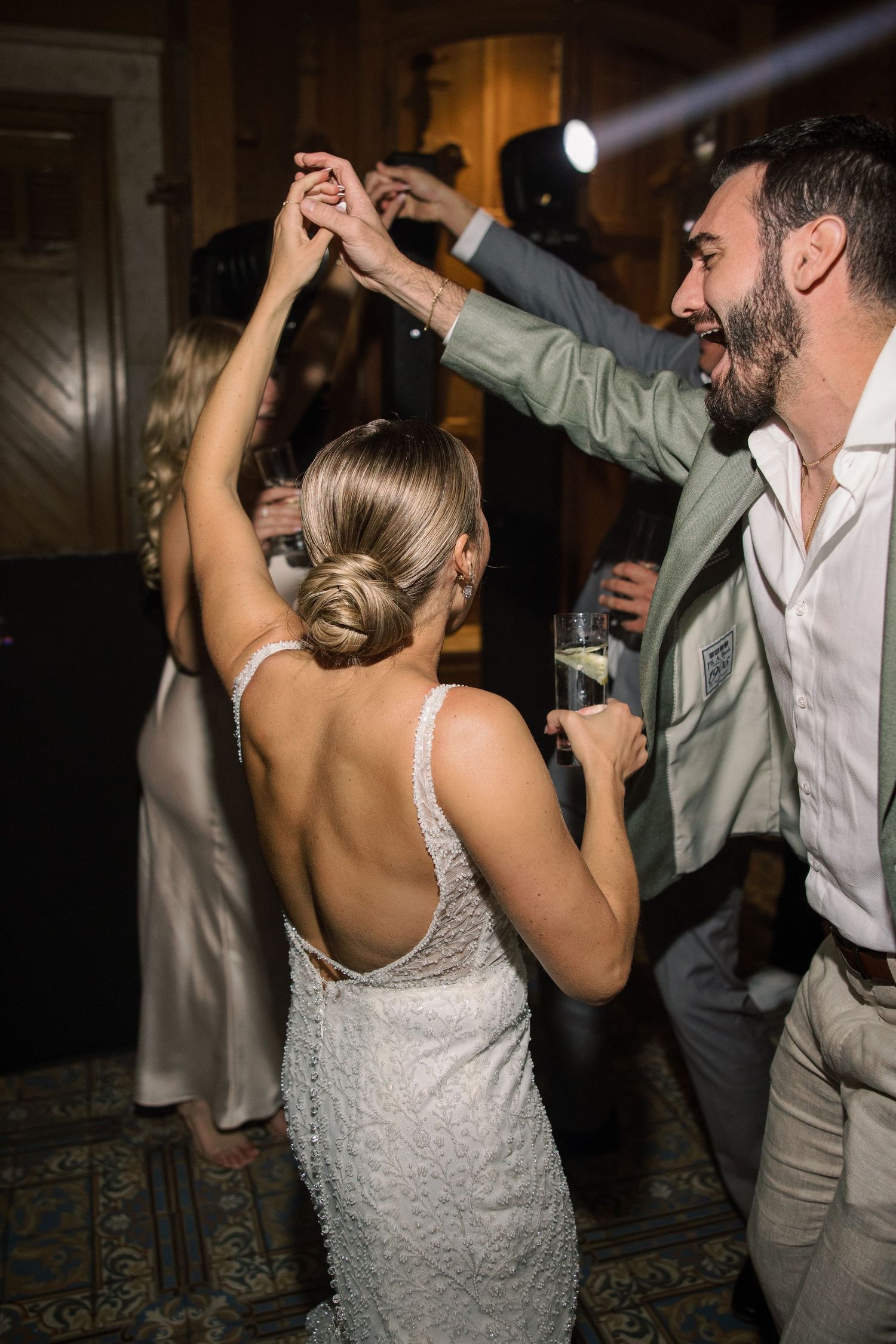 Couple dancing energetically on the dance floor at wedding reception.