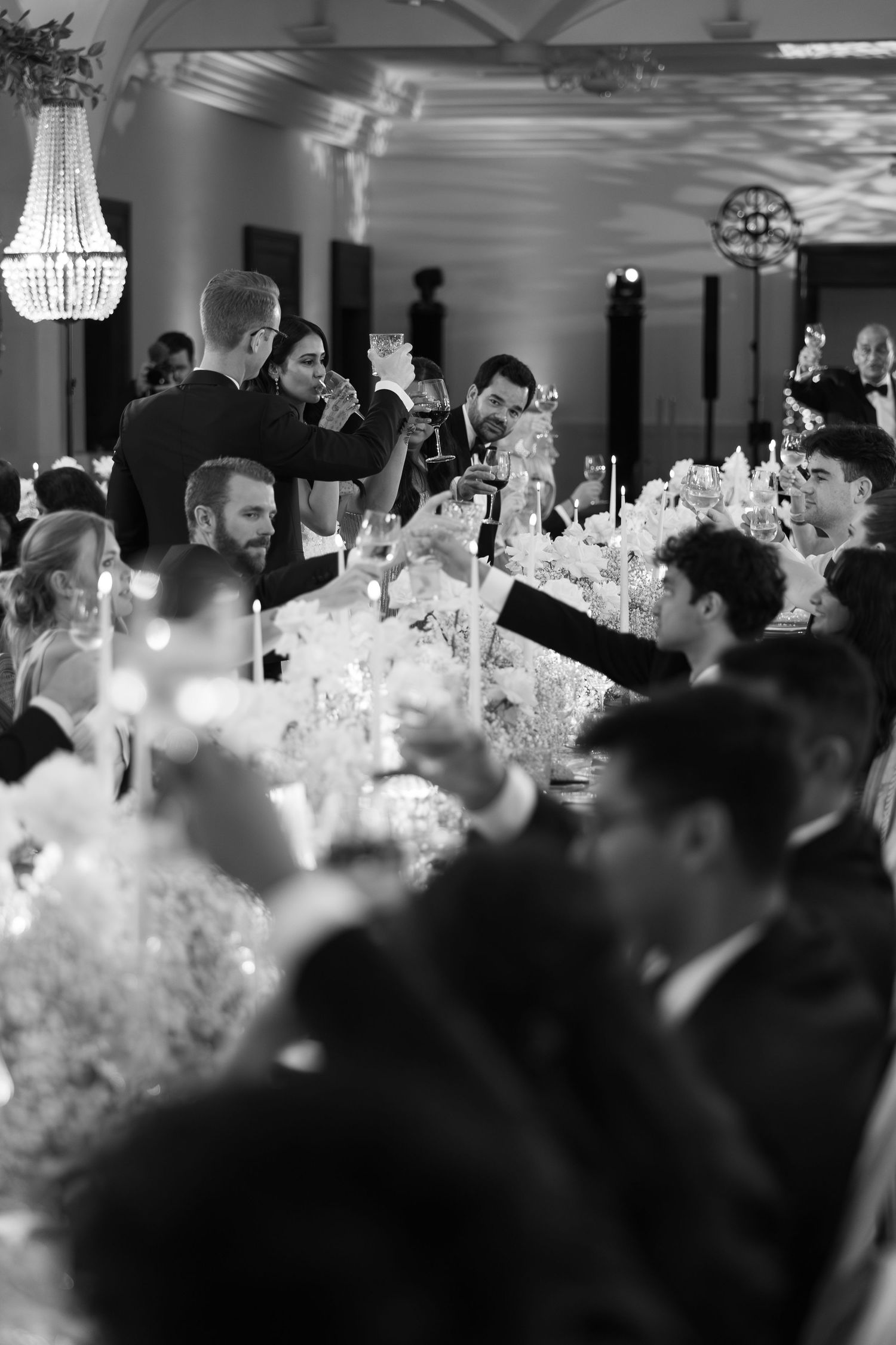 Candlelit wedding reception with guests dining at elegantly decorated tables.