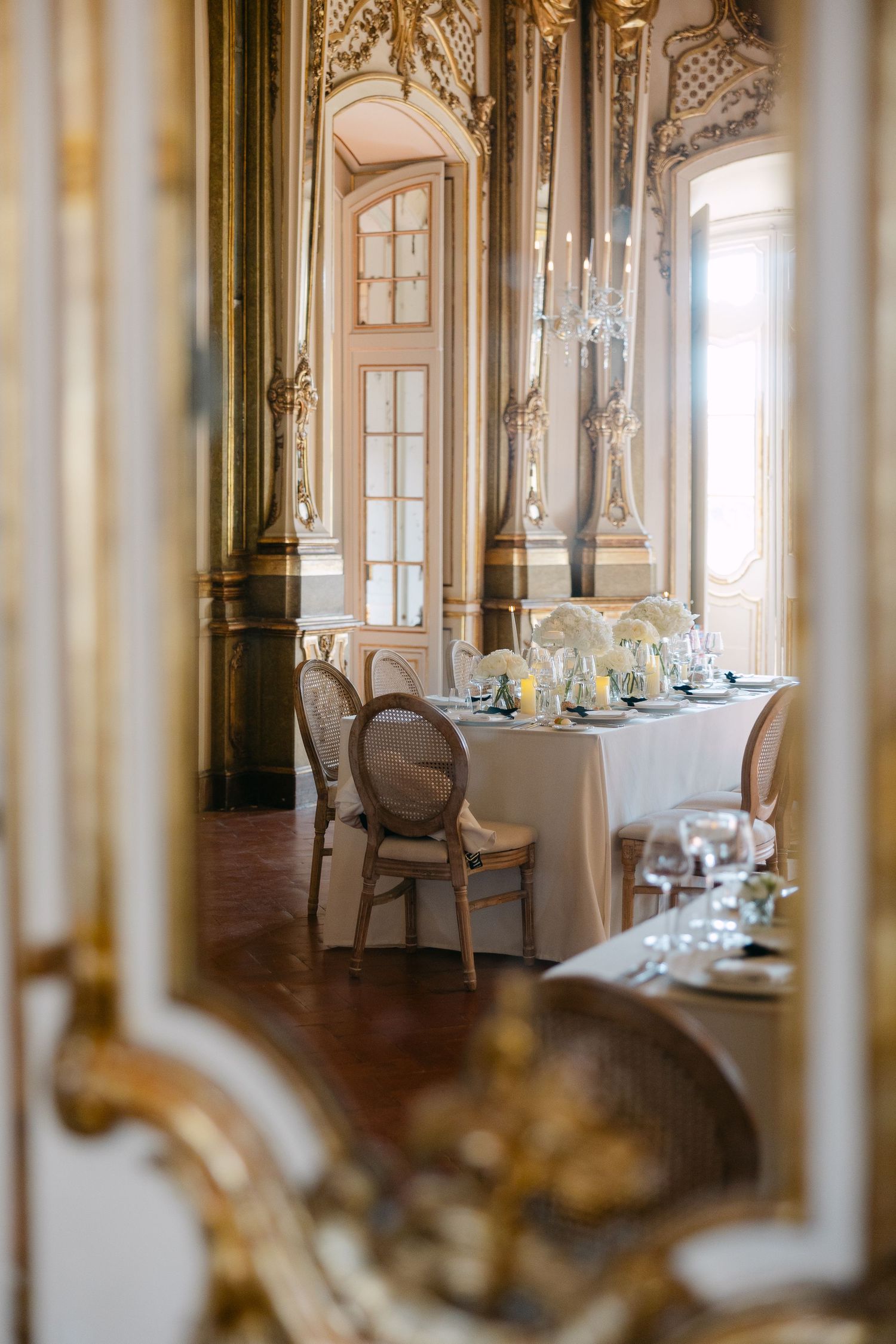 Ornate baroque-style dining room with gilded details and elegant table settings.