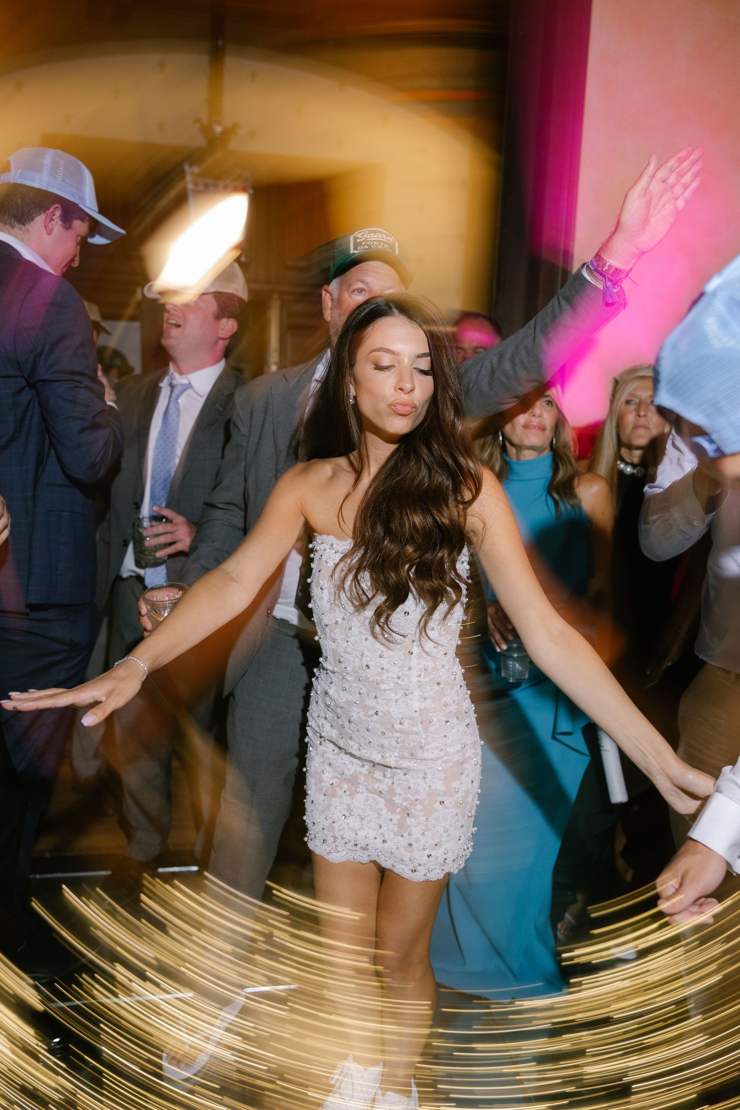 Dynamic dance floor scene with motion blur and party lights at a wedding reception.