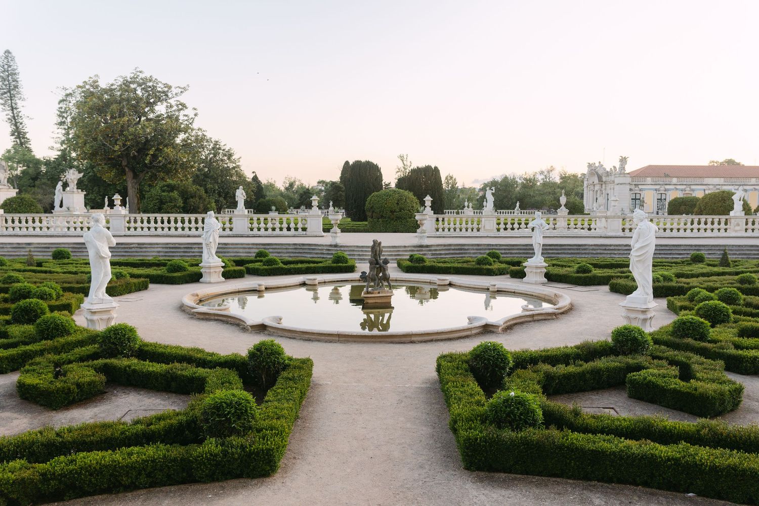 Formal palace gardens featuring circular fountain and symmetrical hedge designs.