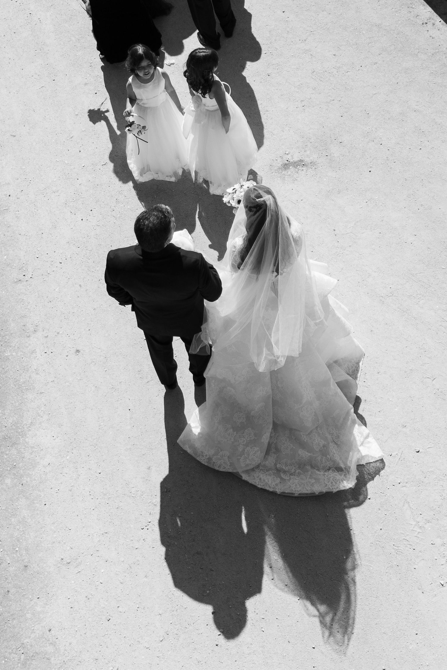 Black and white overhead view of wedding couple dancing on light colored floor.