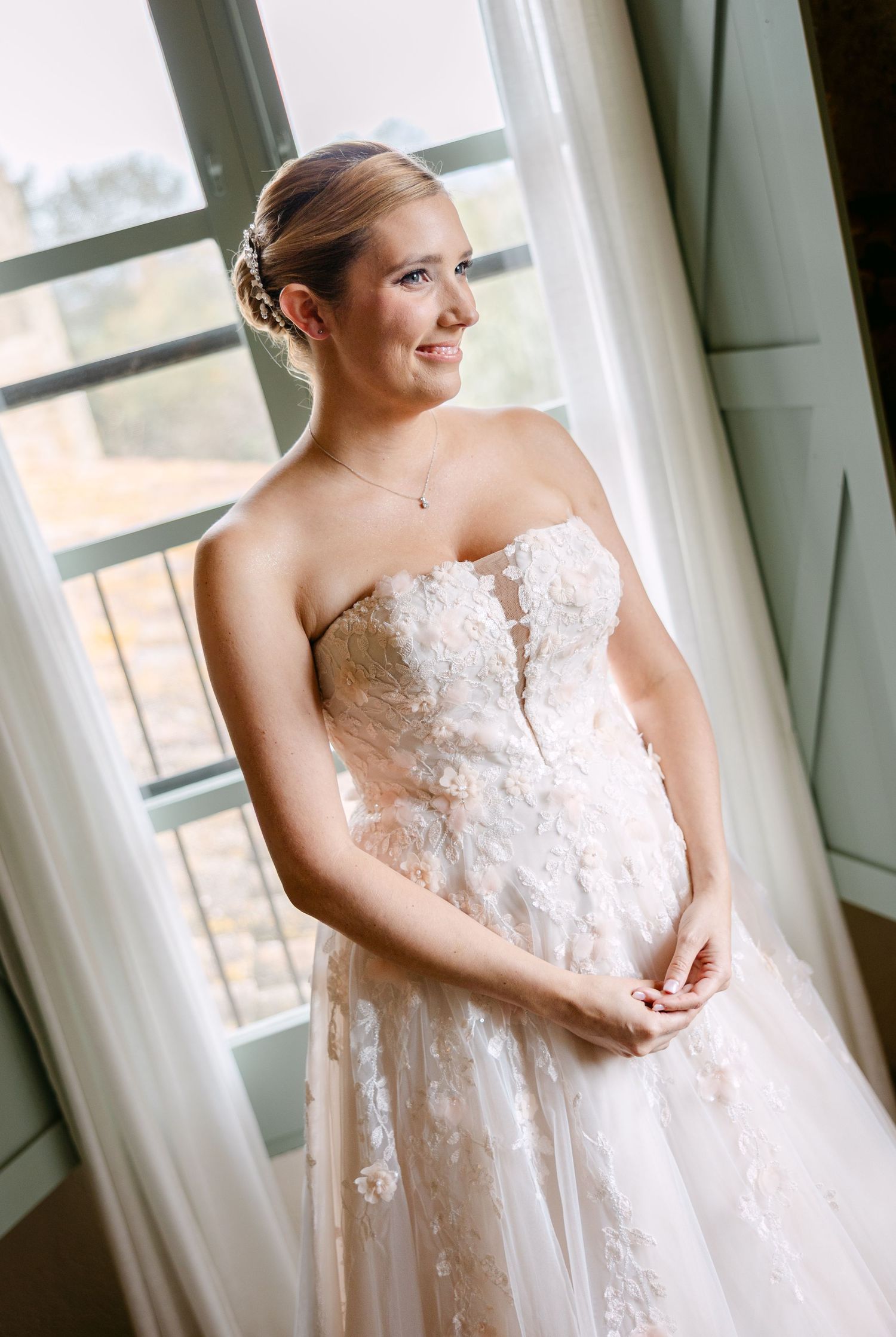 Elegant lace wedding dress with delicate details photographed by window light.