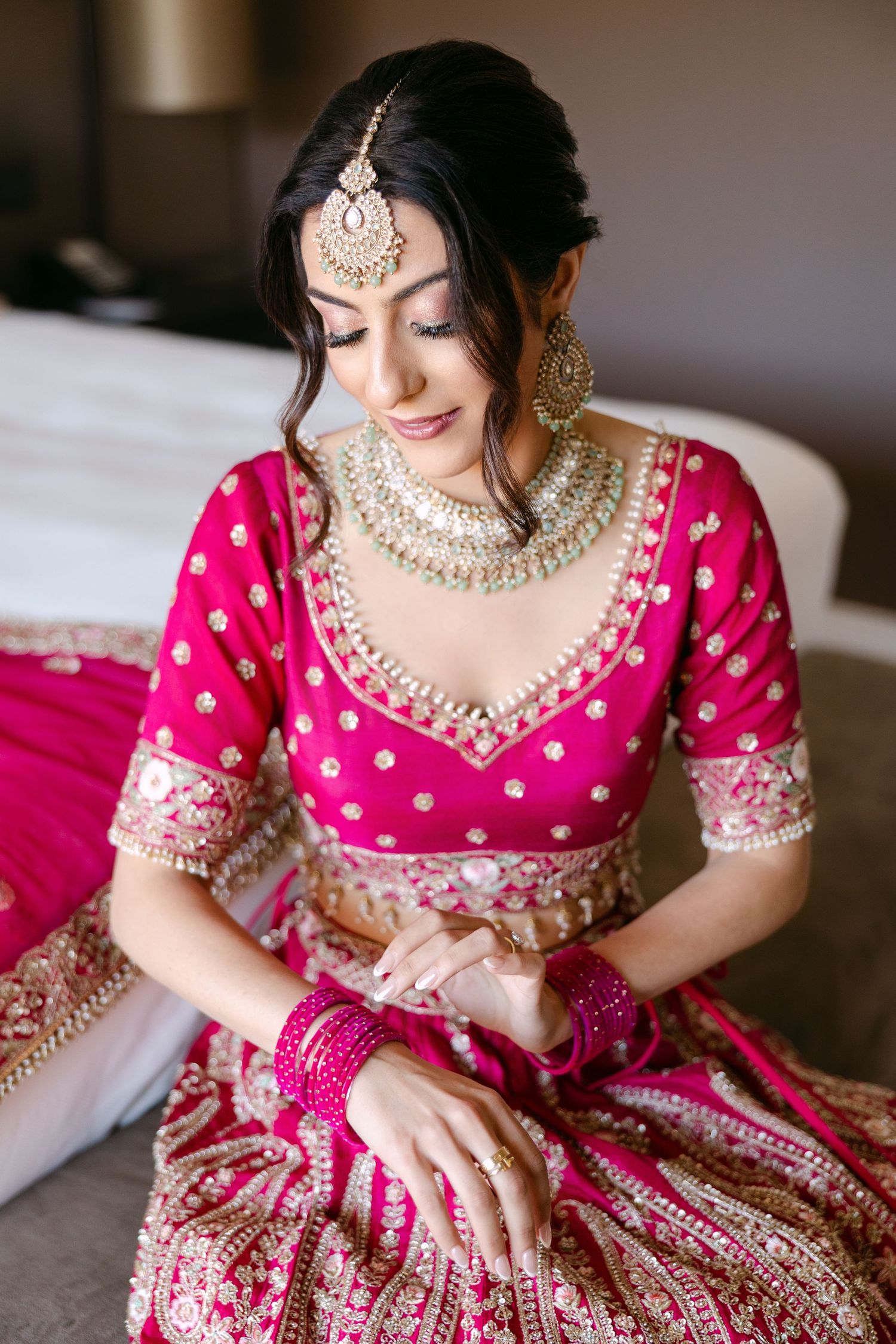 Detailed shots of traditional Indian bridal attire featuring pink embellished fabric and jewelry.